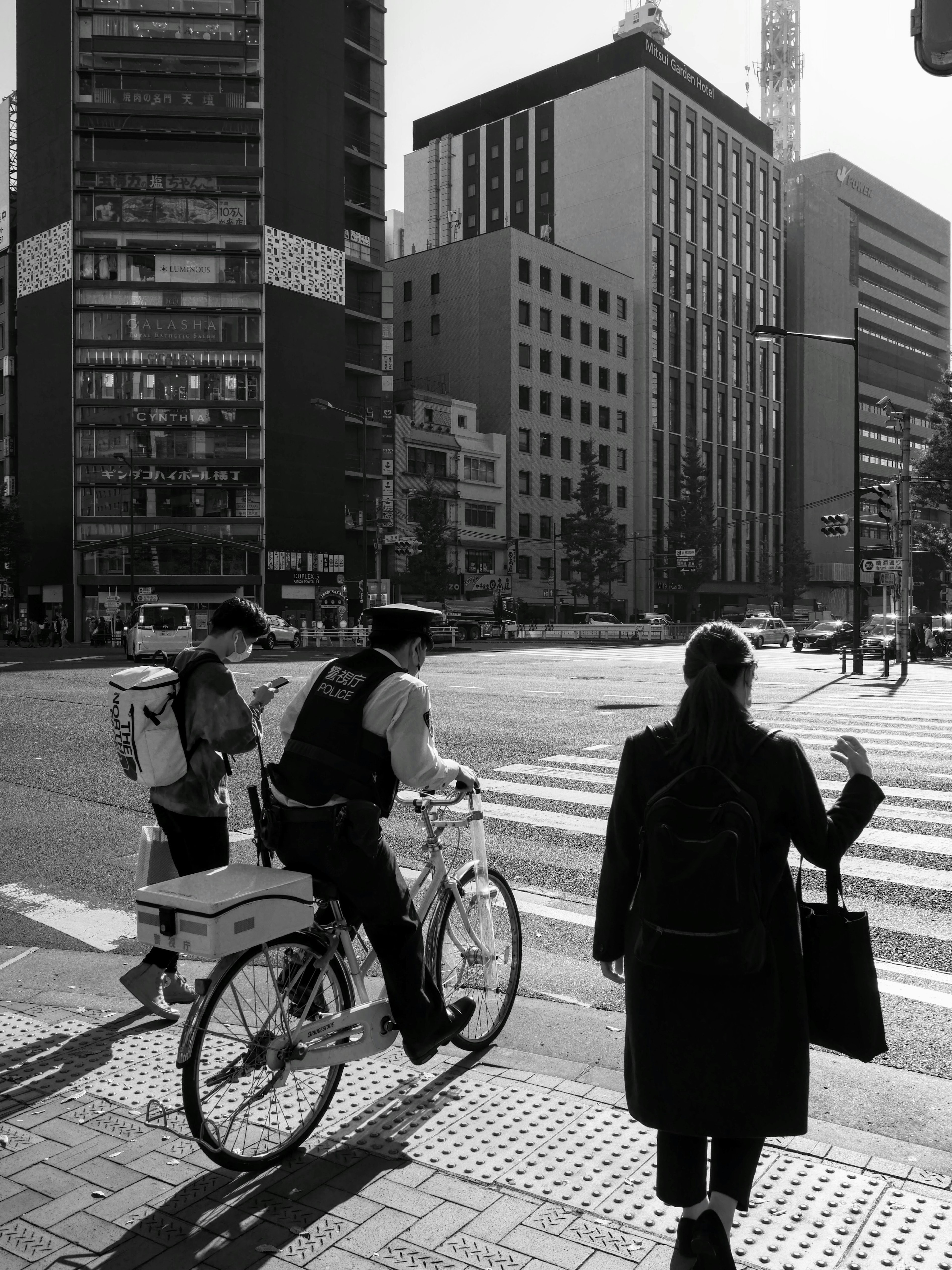 Seorang pengendara sepeda mengantarkan barang di zebra cross dengan pejalan kaki