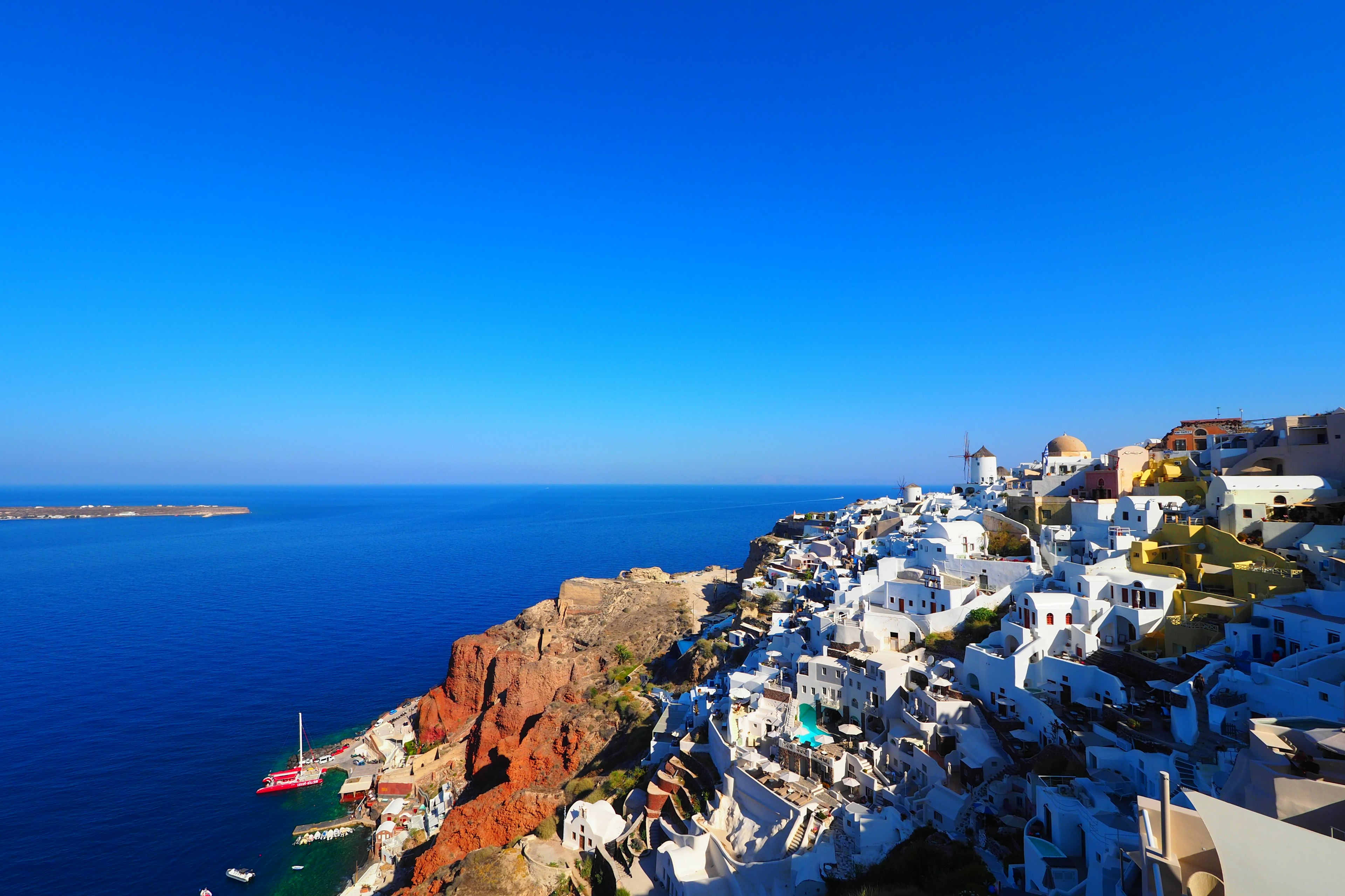 Weiße Gebäude von Santorin umgeben von blauem Himmel und Meer