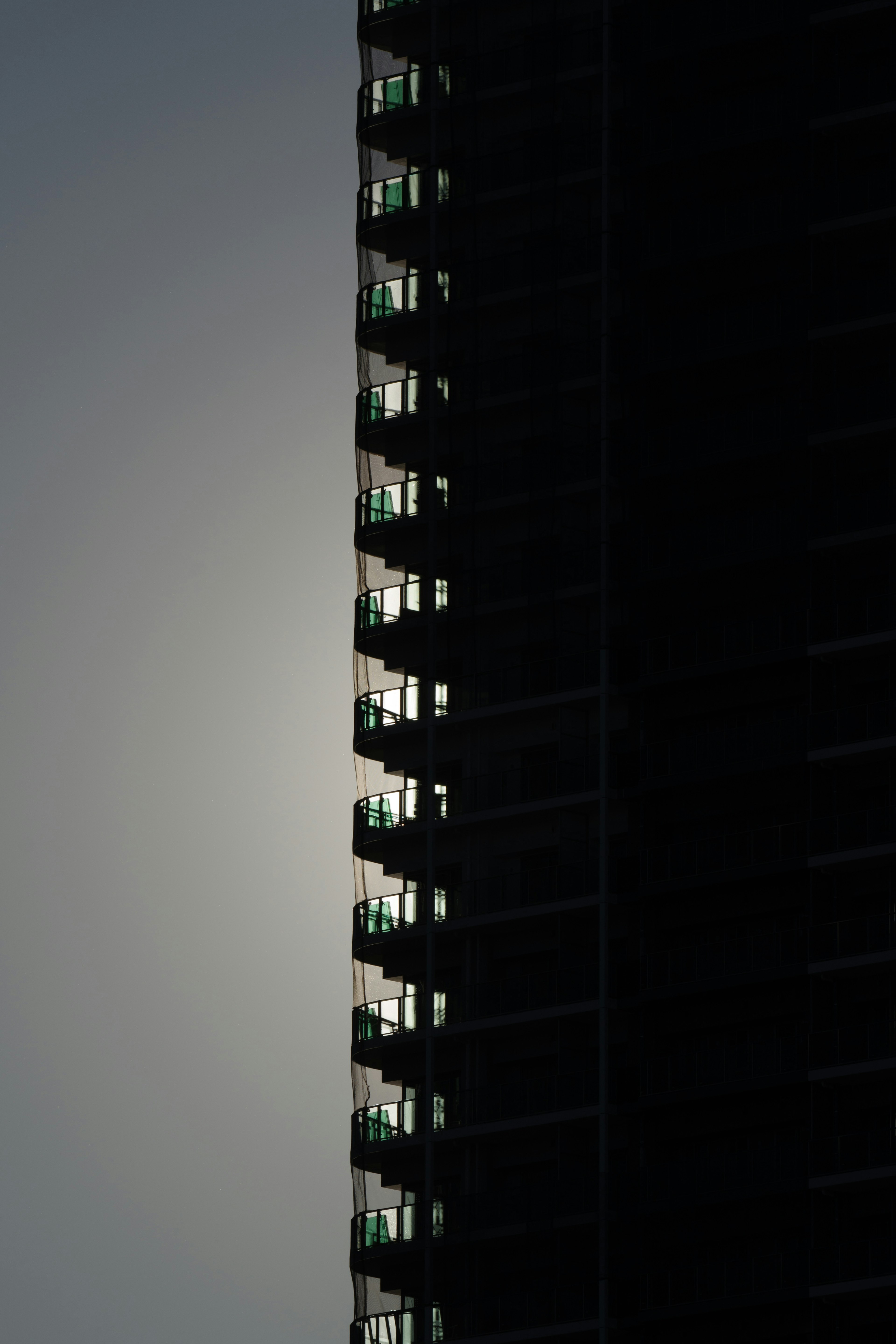 Silhouette d'un immeuble de grande hauteur avec balcons dans l'ombre