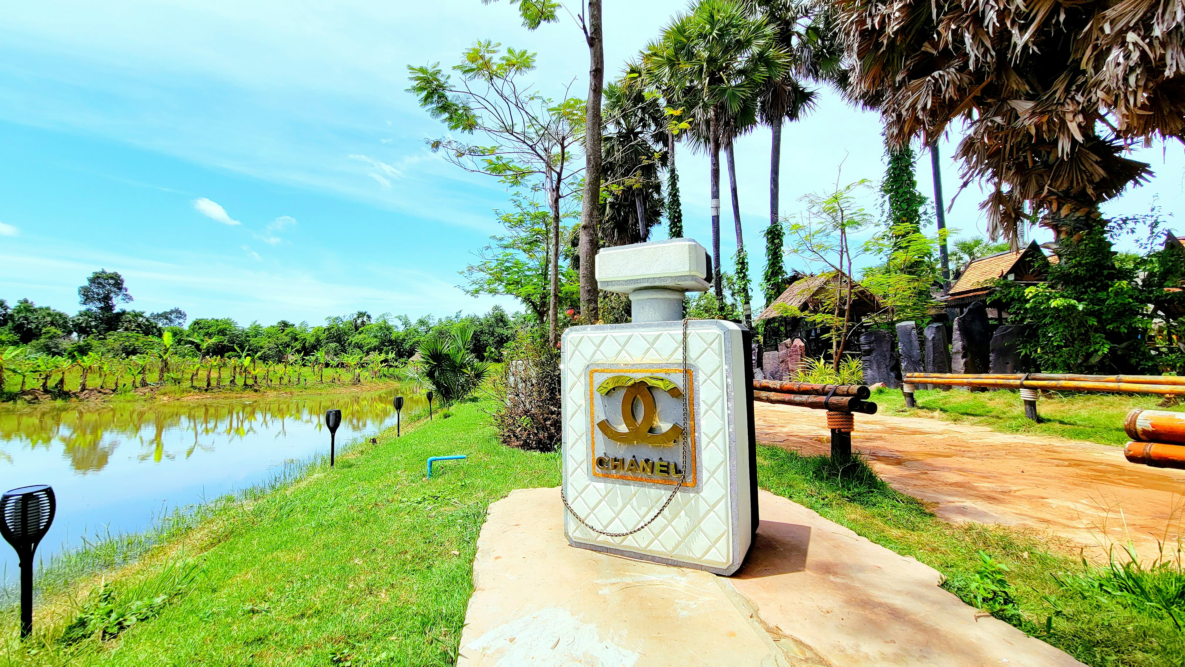 Parfümflasche in einer üppigen Landschaft mit blauem Himmel