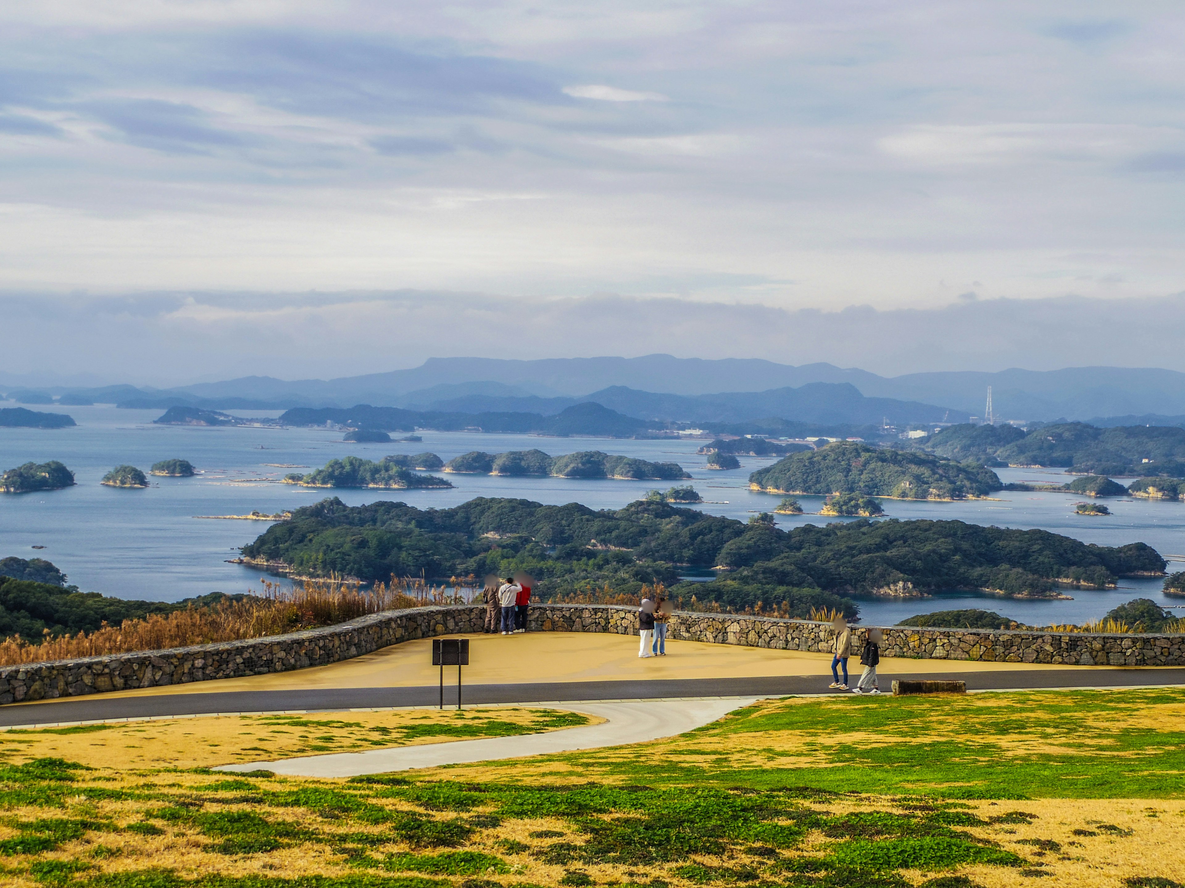 Vista escénica de islas en el océano con cielo azul y turistas en un mirador