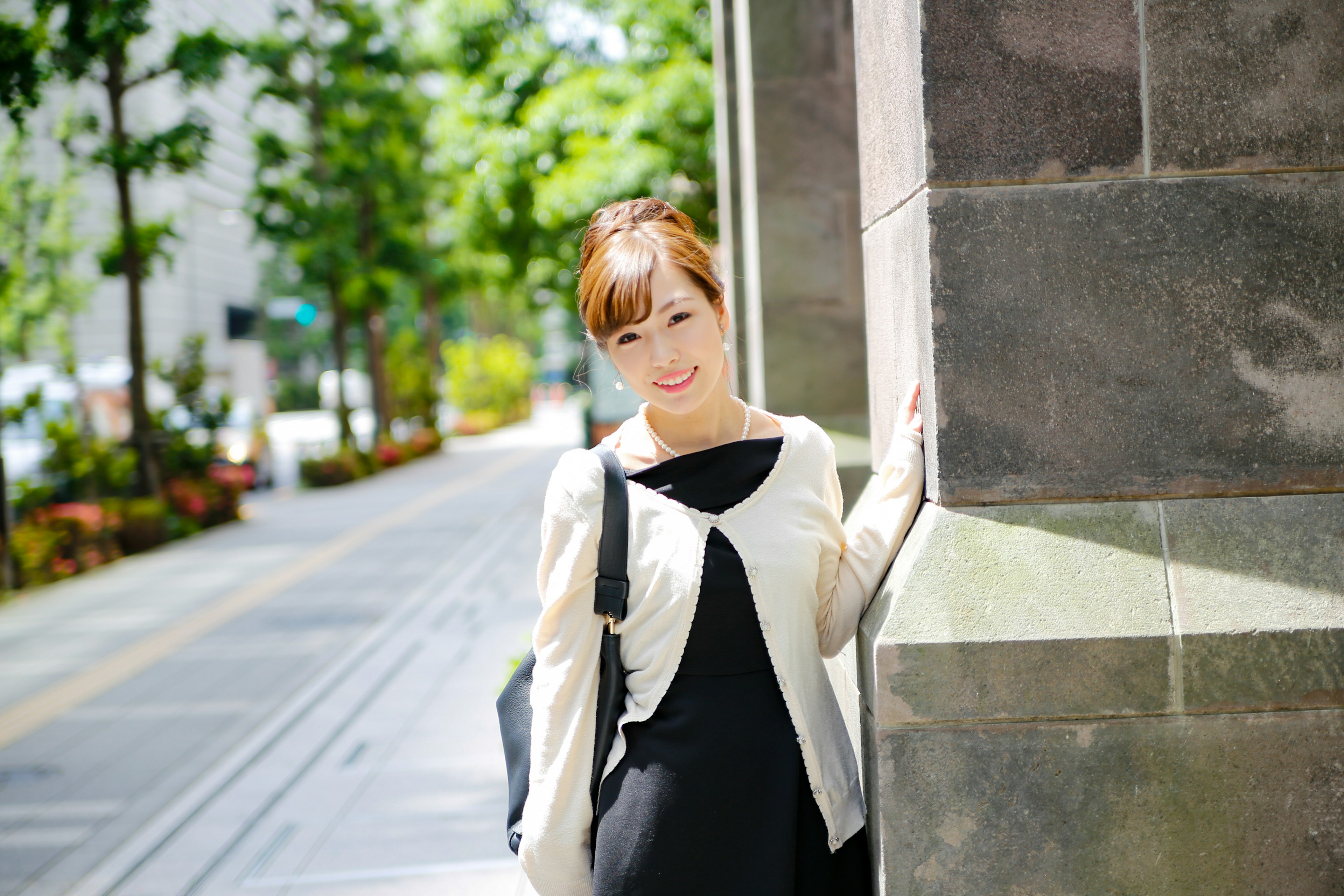 Portrait of a smiling woman in the city with green trees in the background