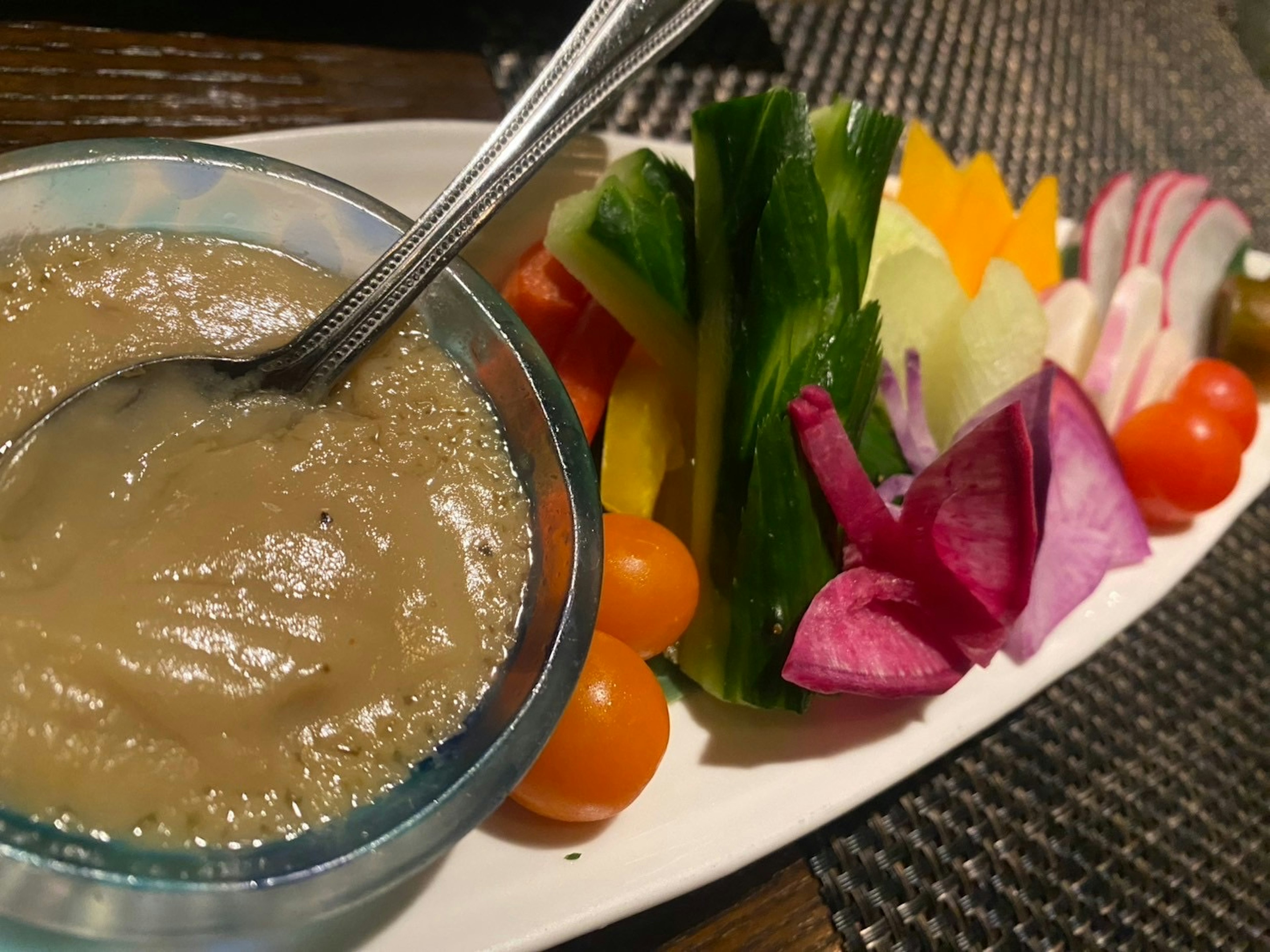 Un plato de verduras frescas con una salsa para mojar