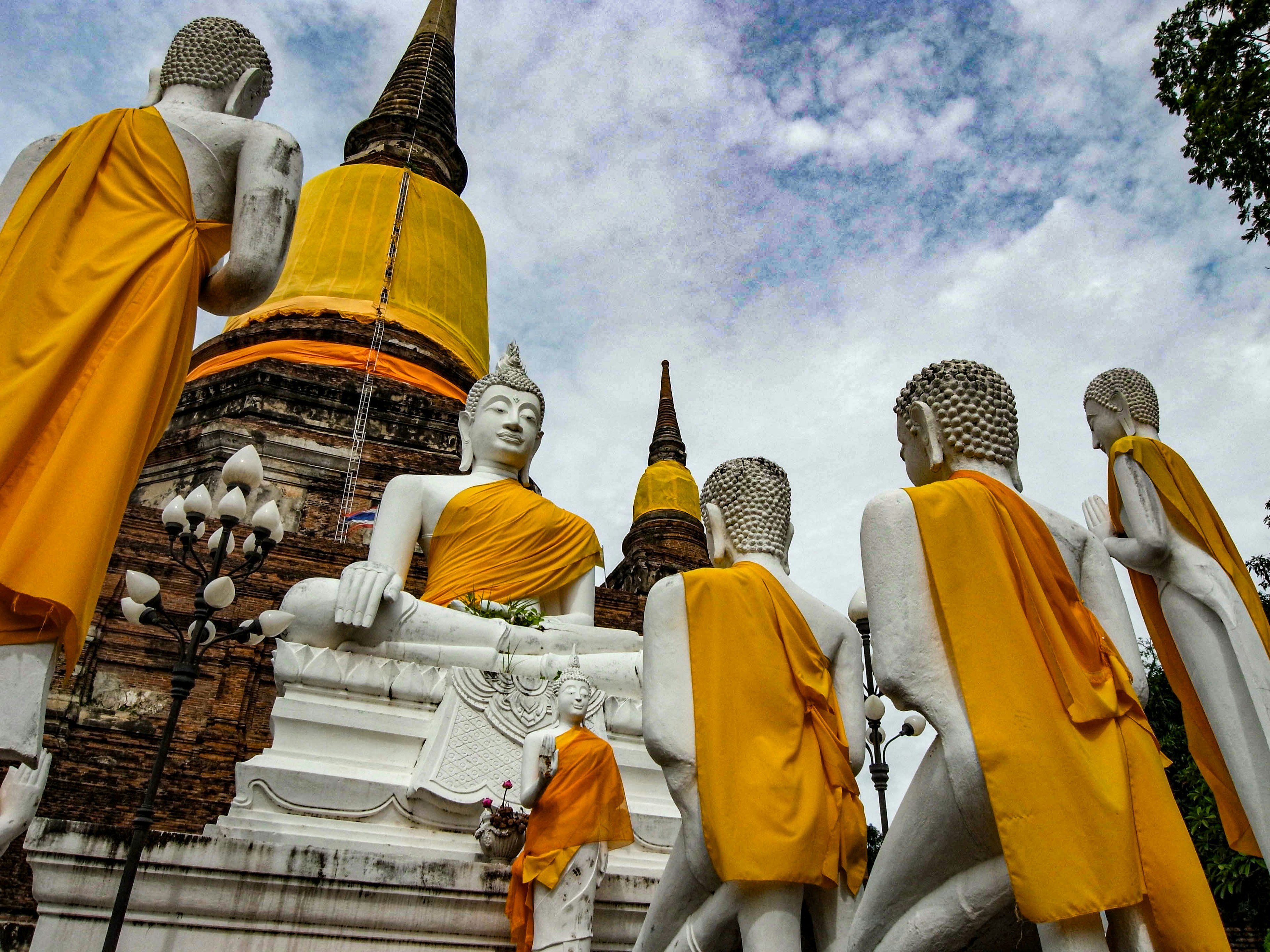 Statues de Bouddha avec des moines en robes jaunes dans un temple