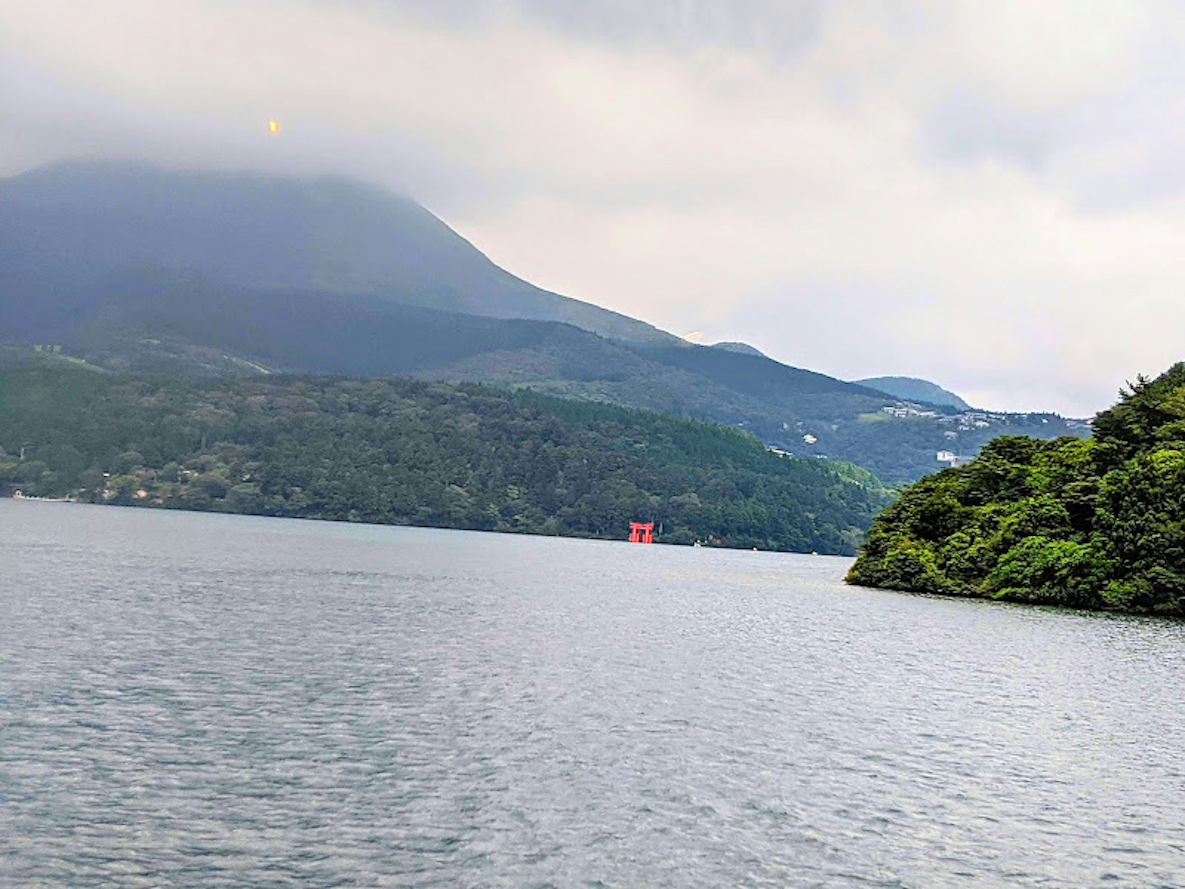 湖と山の風景に赤い鳥居が見える