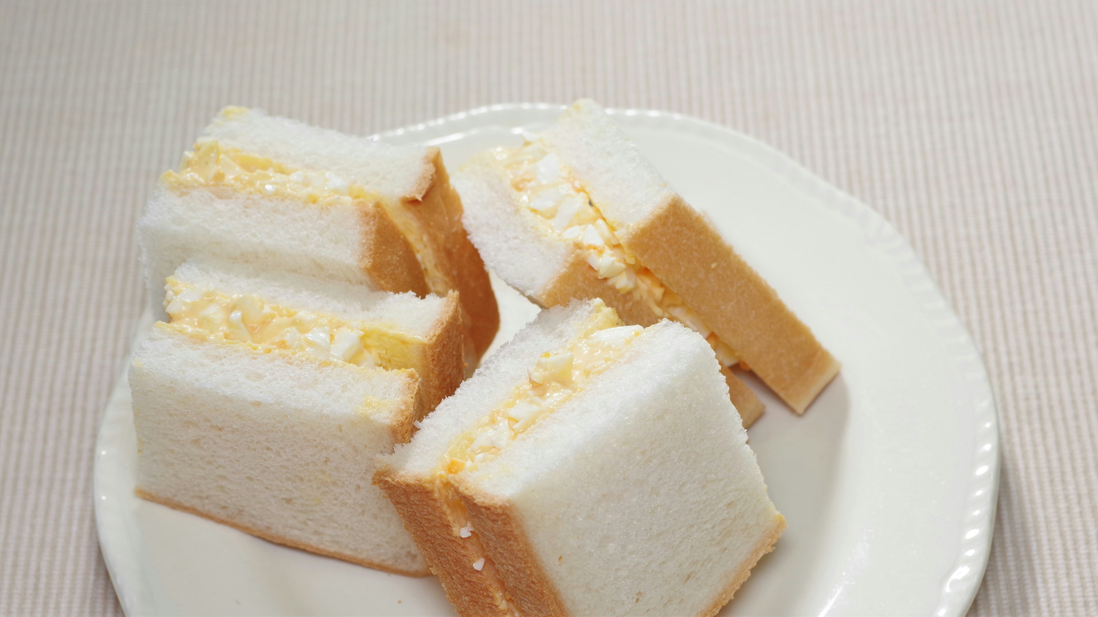 Ein Teller mit weißen Sandwiches mit cremiger Füllung