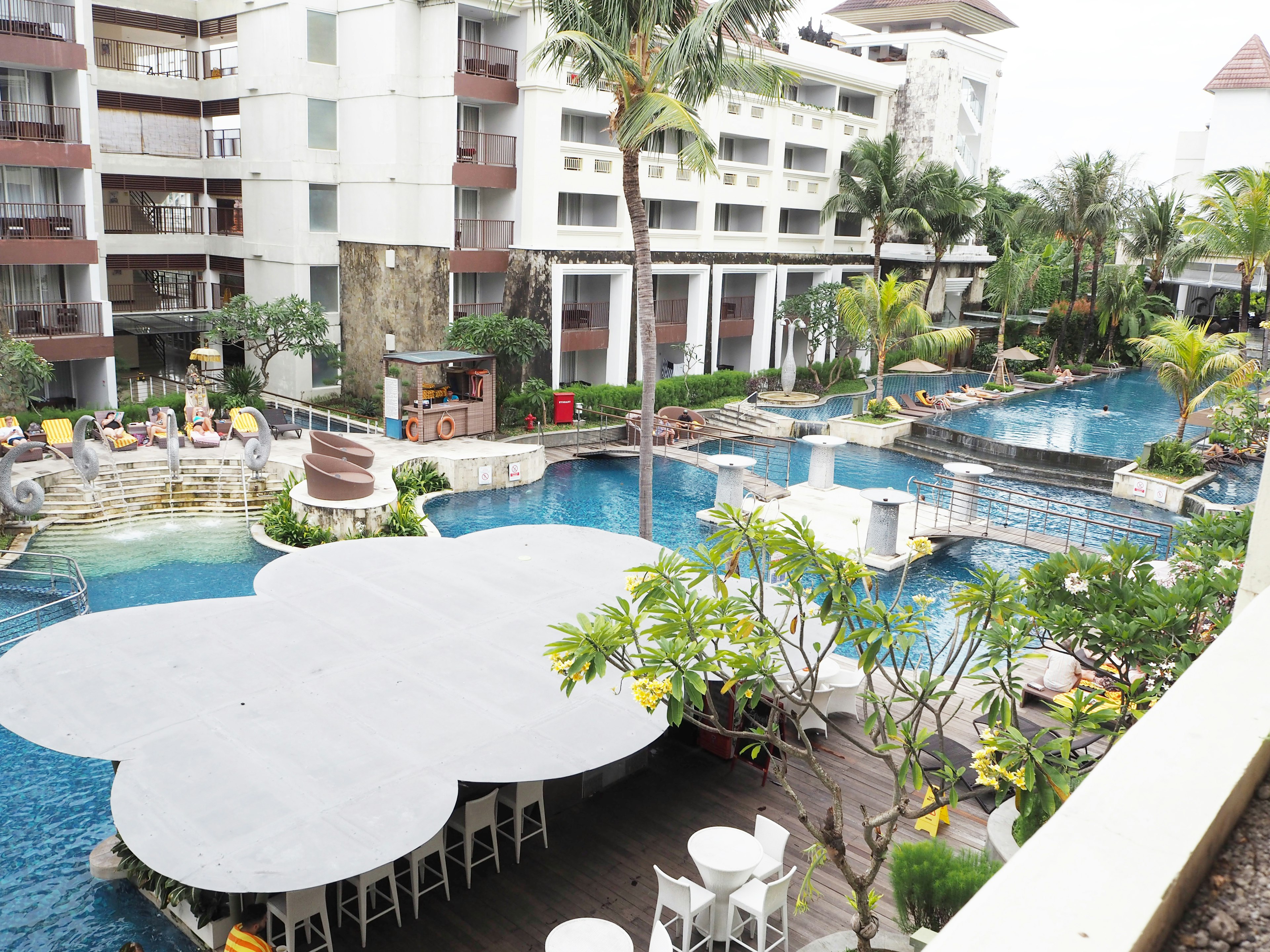 View of a resort hotel pool area with lush greenery