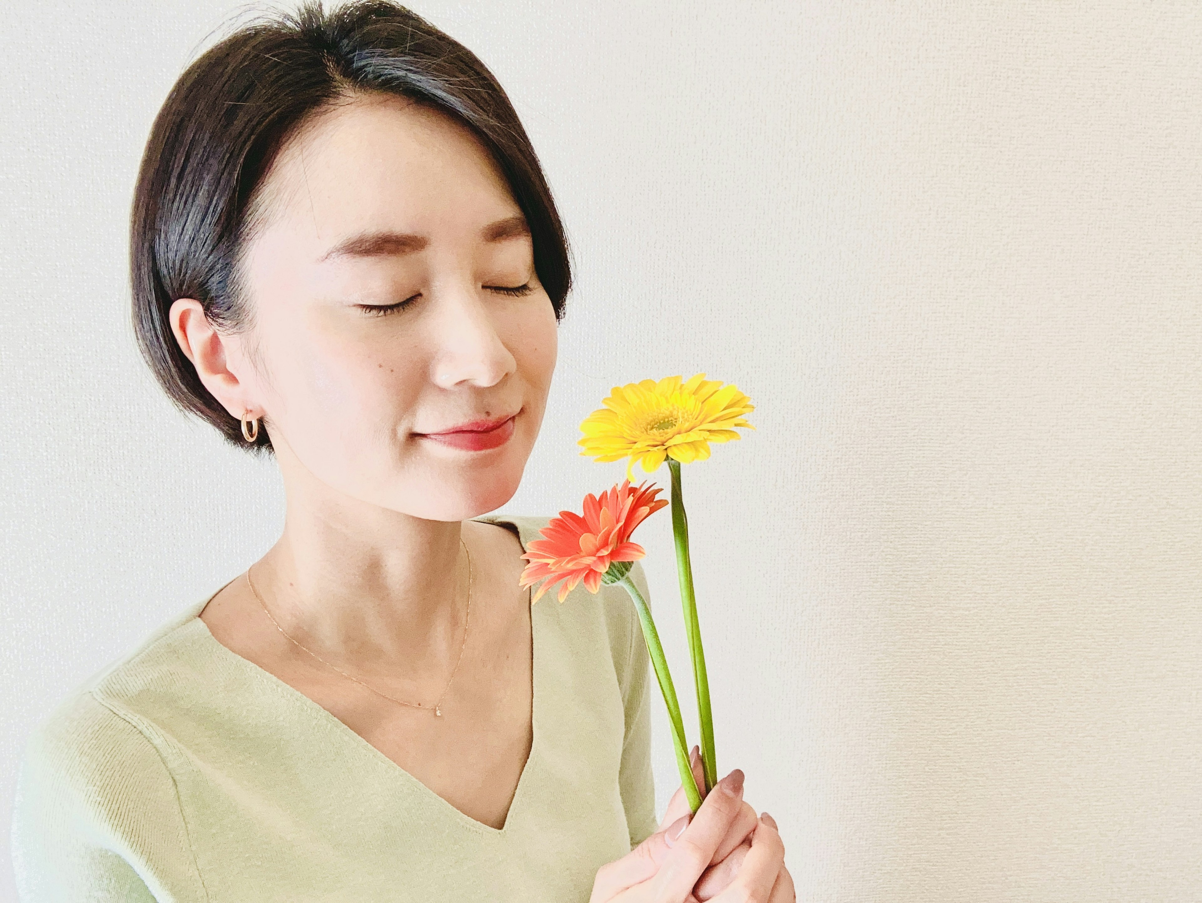 Mujer sosteniendo flores con una expresión serena