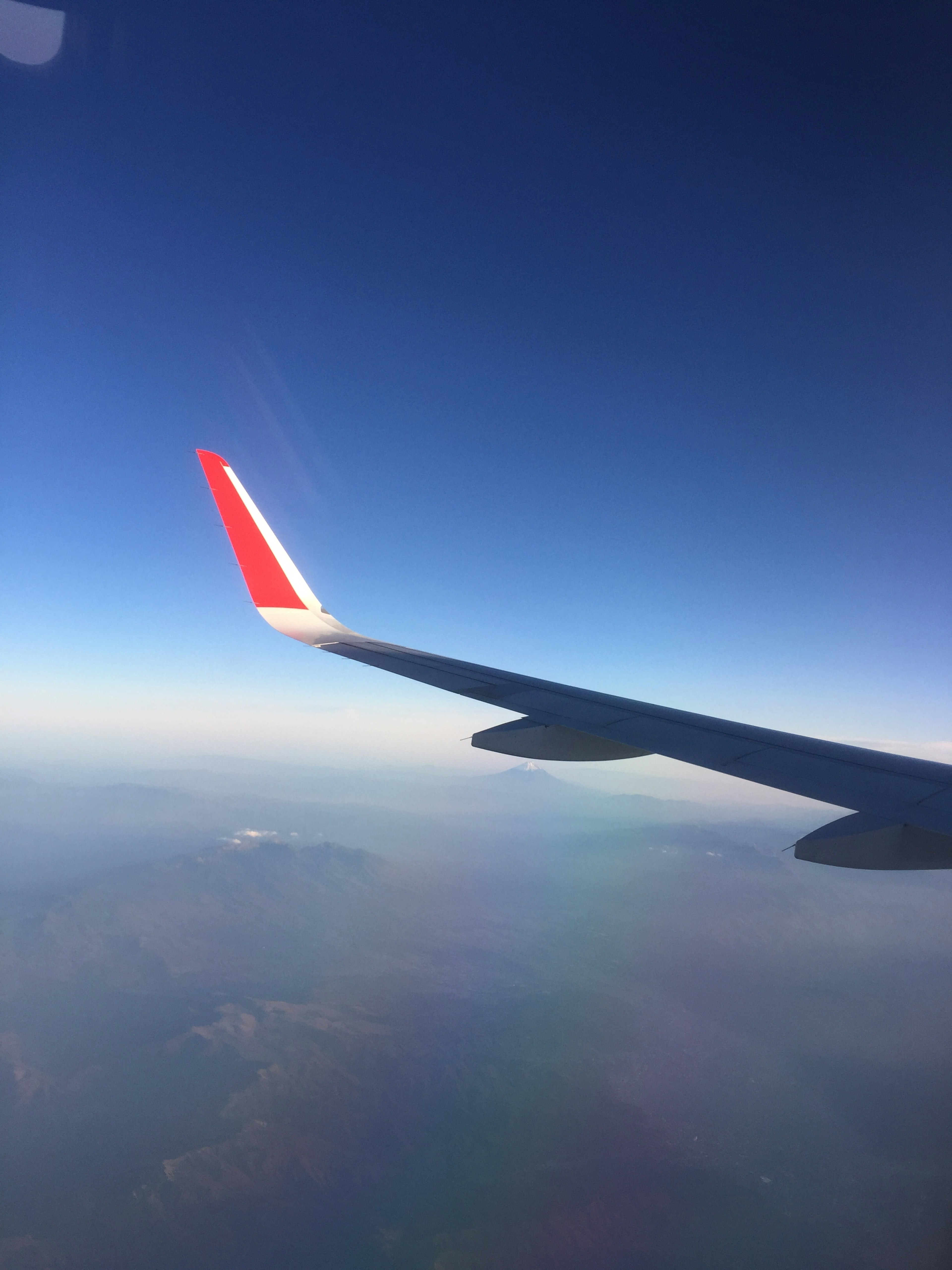 Airplane wing against a clear blue sky