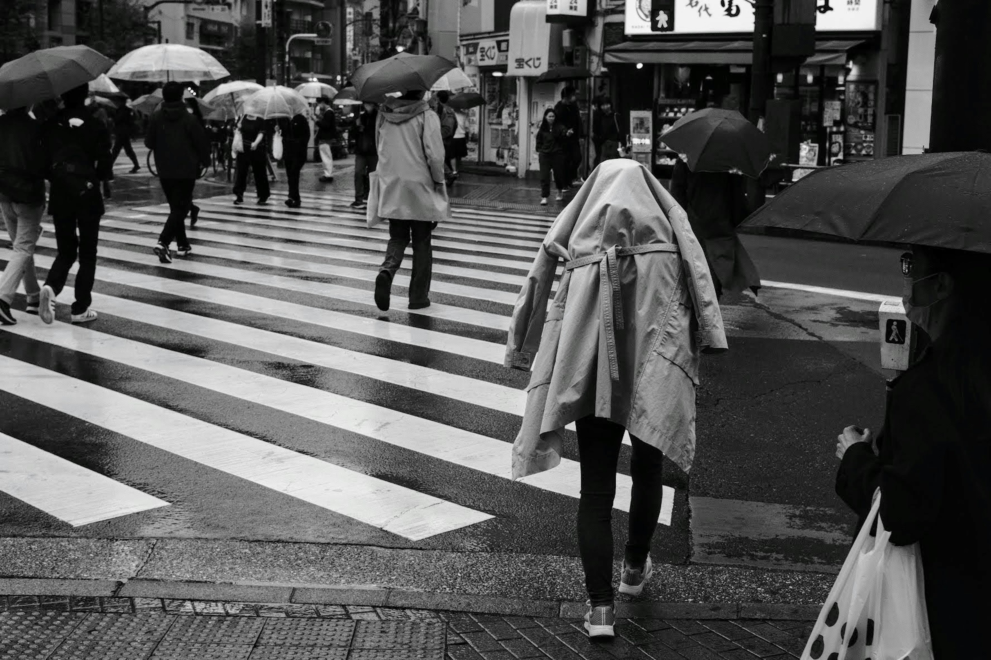 雨の中で歩く人々と傘の風景が広がる横断歩道