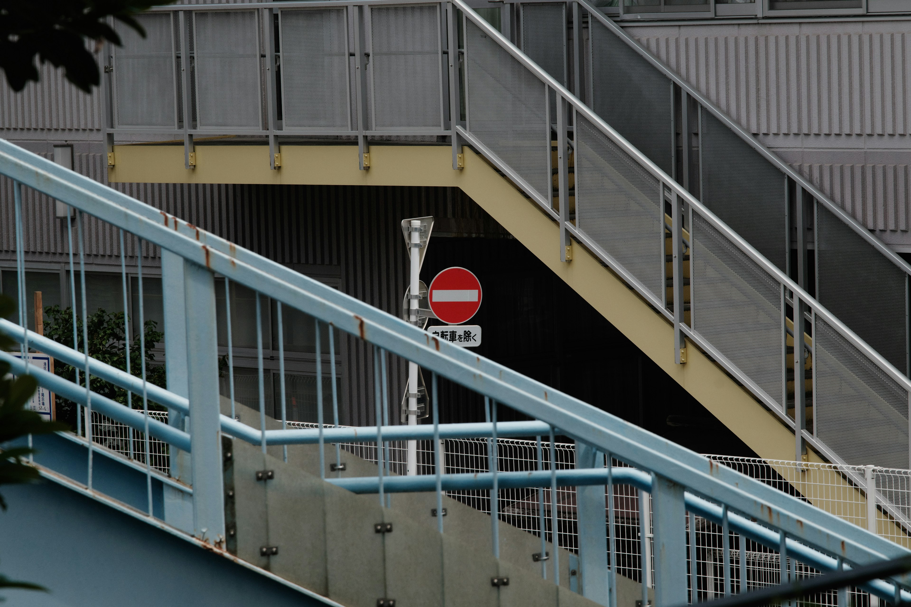 Scène urbaine avec des escaliers et un panneau d'interdiction rouge