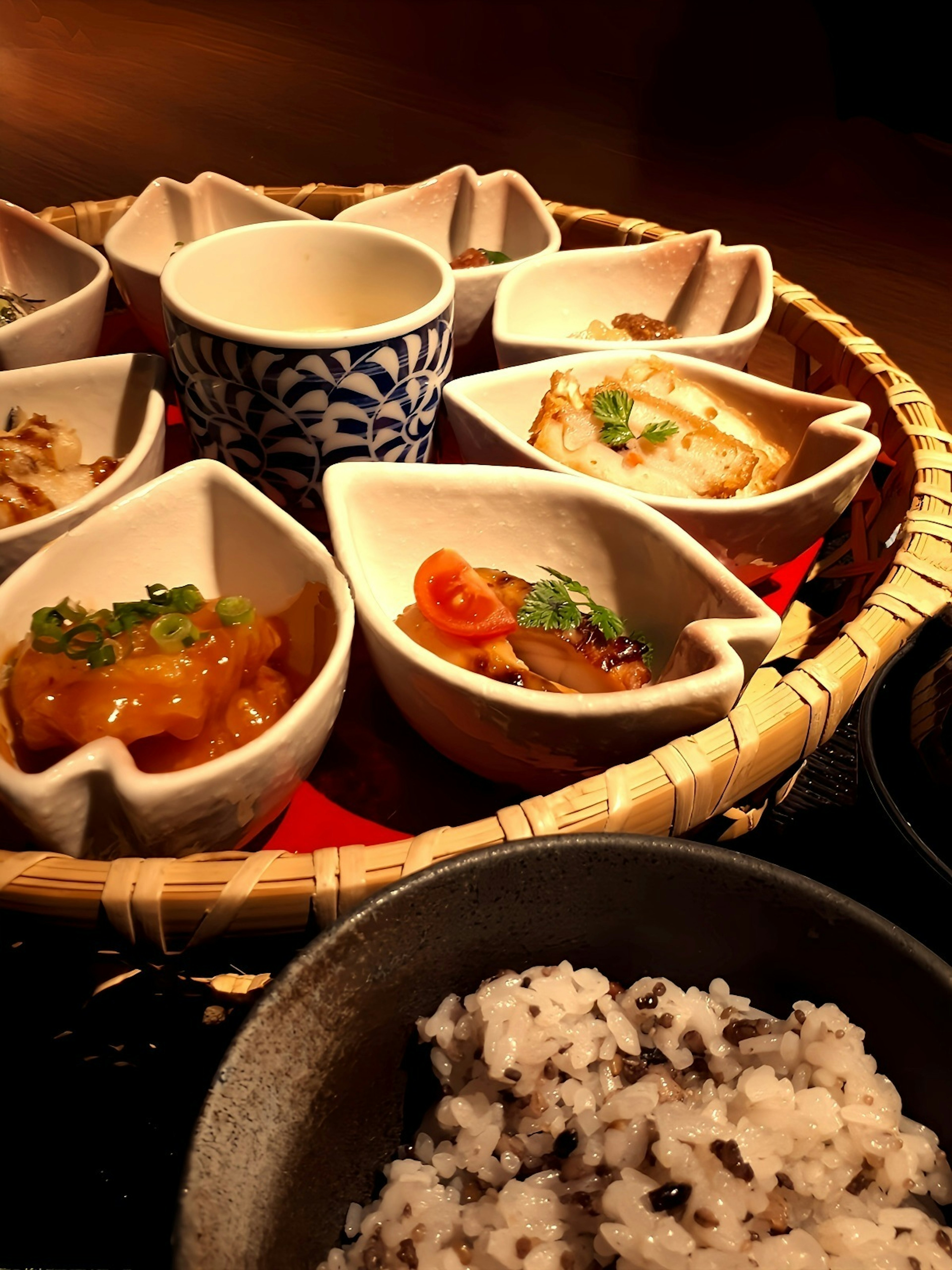 Comida japonesa tradicional servida en una cesta tejida con arroz negro