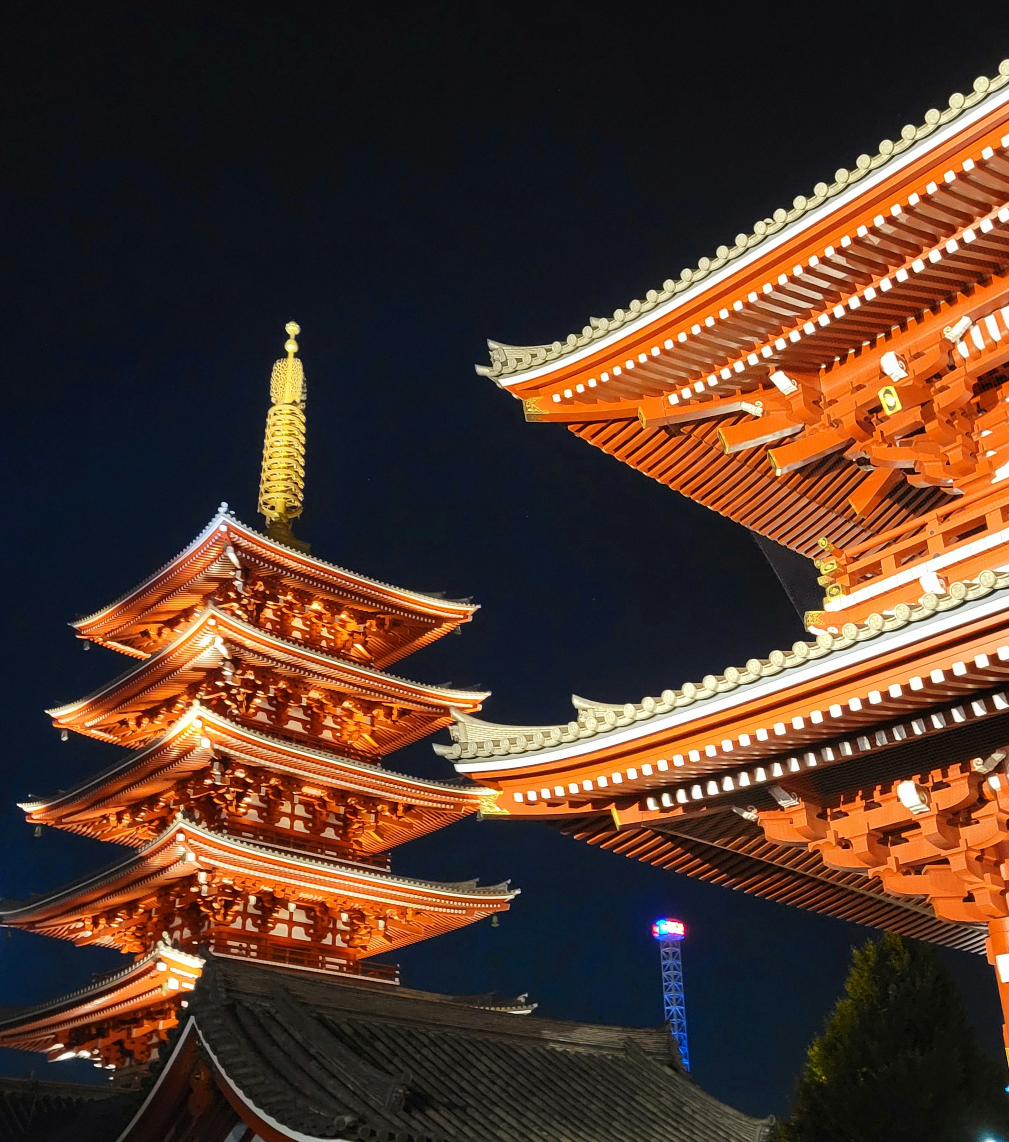 Vista notturna della pagoda del tempio Senso-ji e delle strutture con tetto rosso