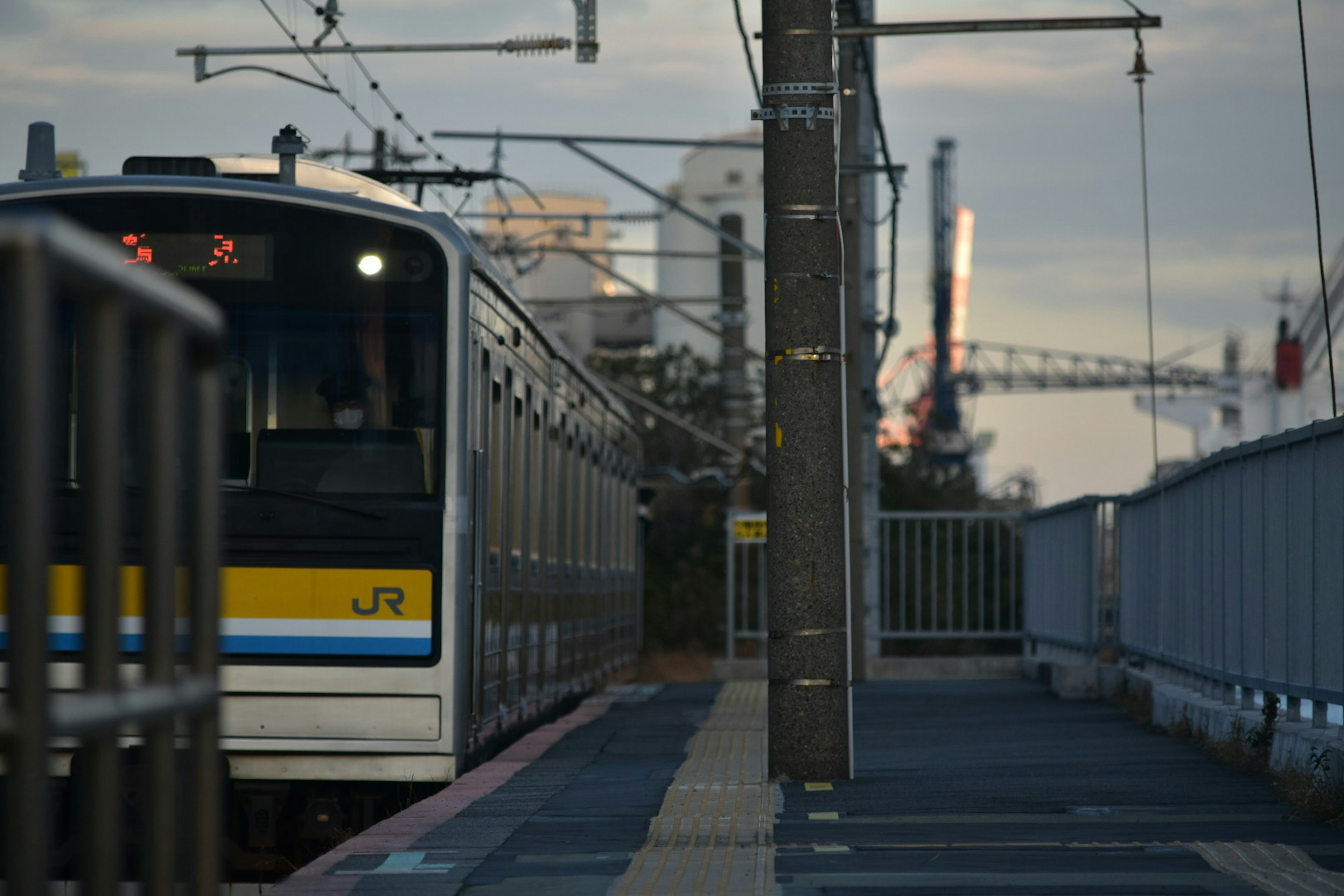 Train at a station platform with a city backdrop