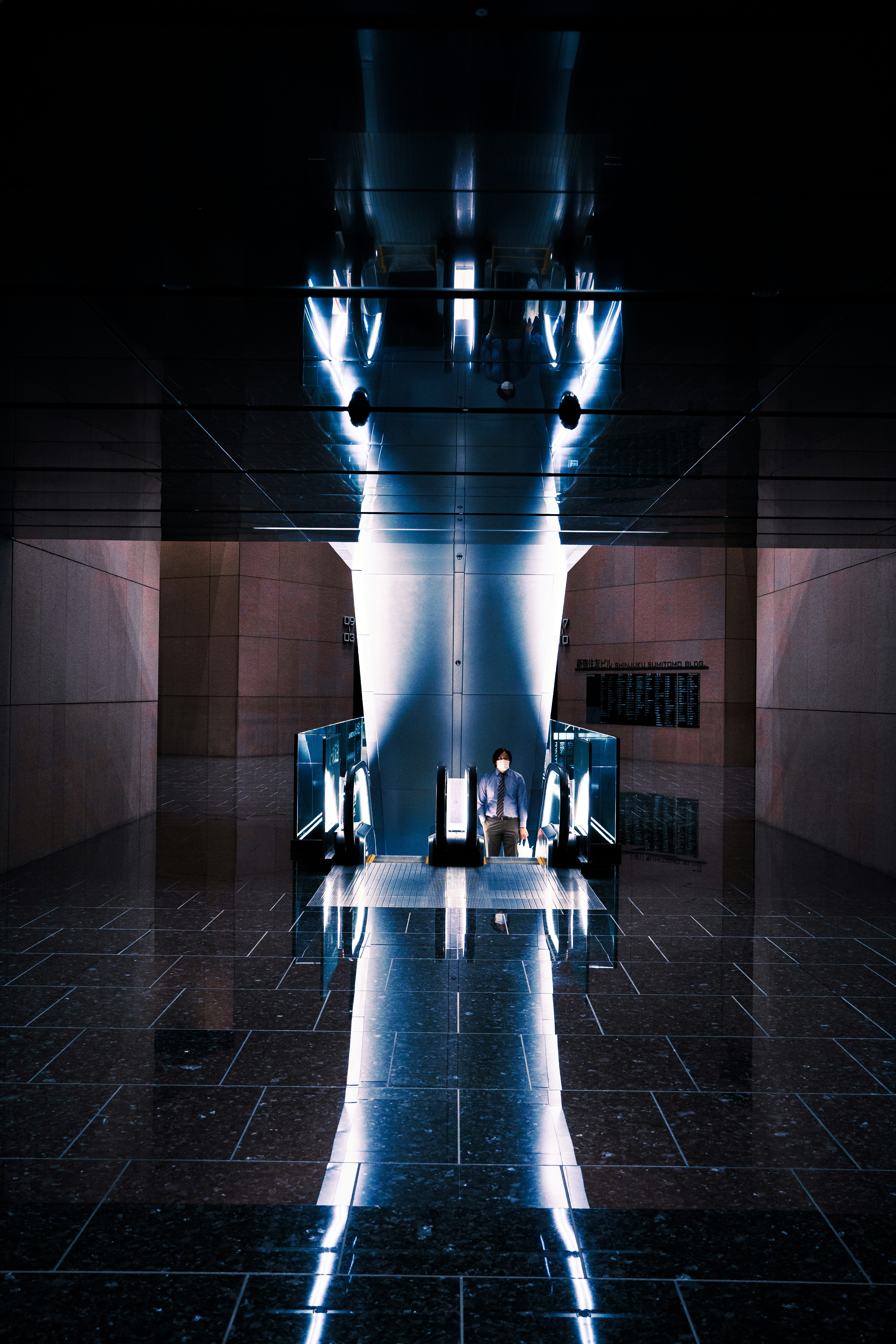 Illuminated column in a dark space with reflective floor