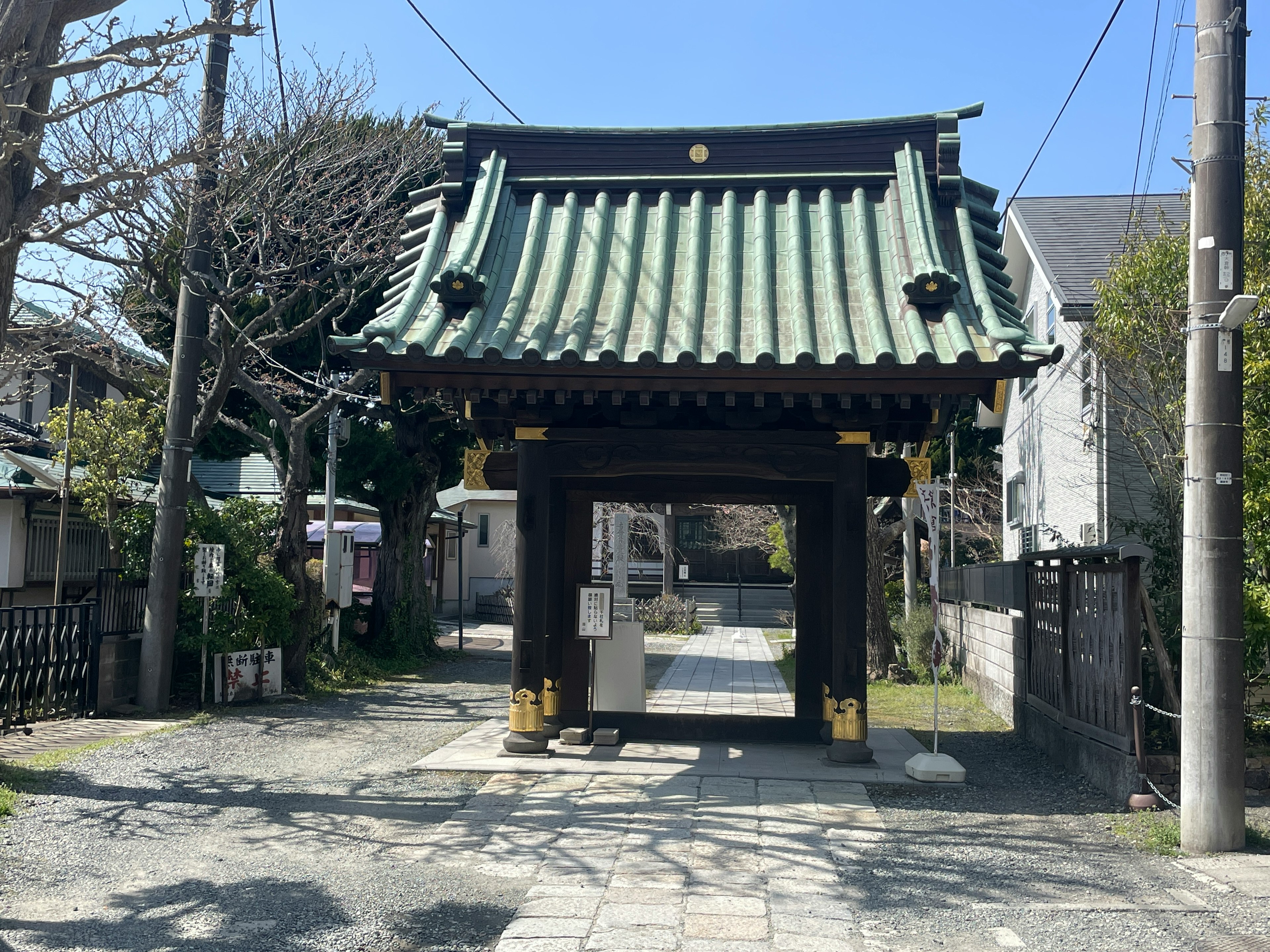 Traditional Japanese gate with a green roof in a serene setting