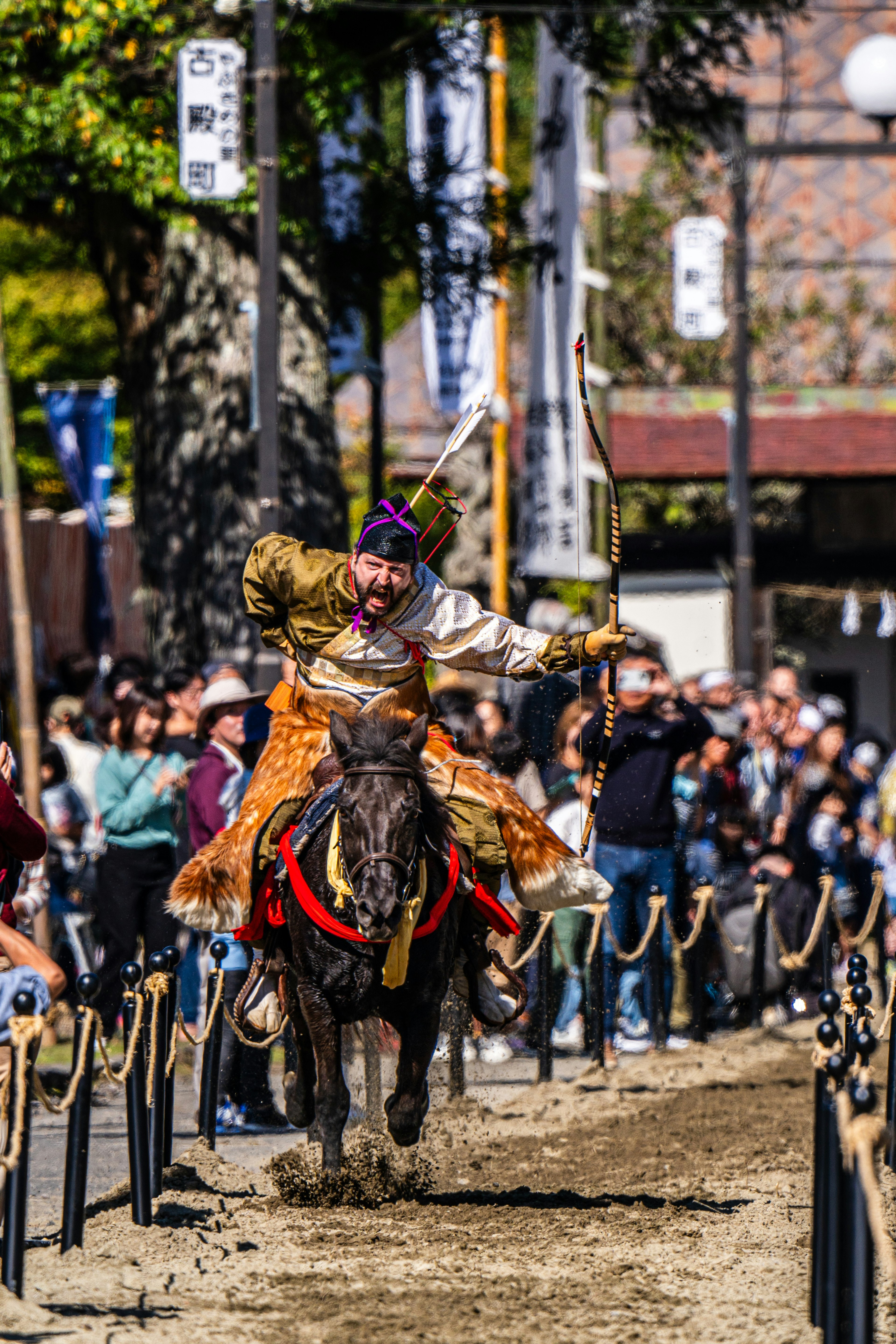 Ein Krieger zu Pferd, der während eines traditionellen Festivals einen Bogen spannt