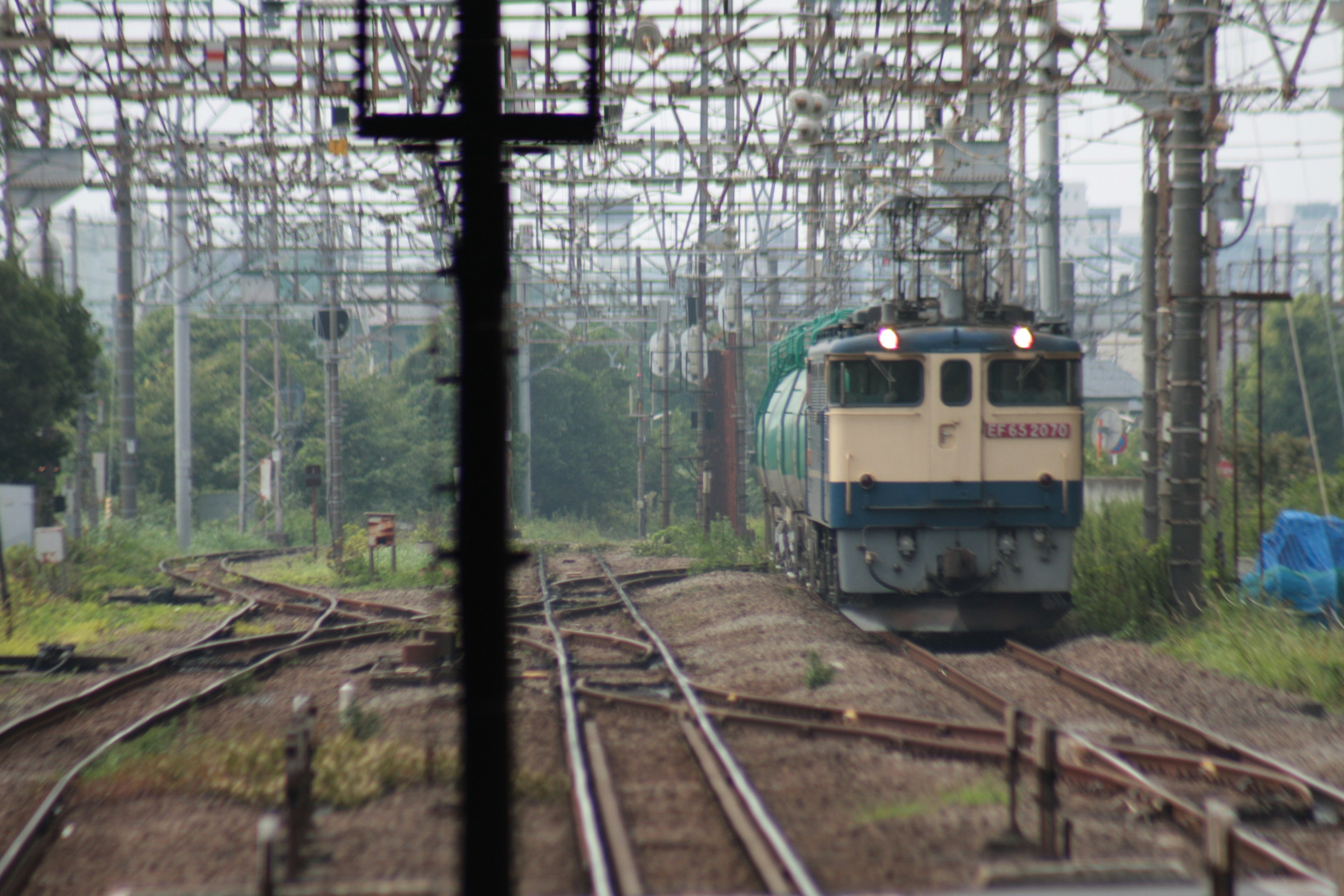 Sebuah kereta mendekat di beberapa jalur kereta dengan kabel overhead