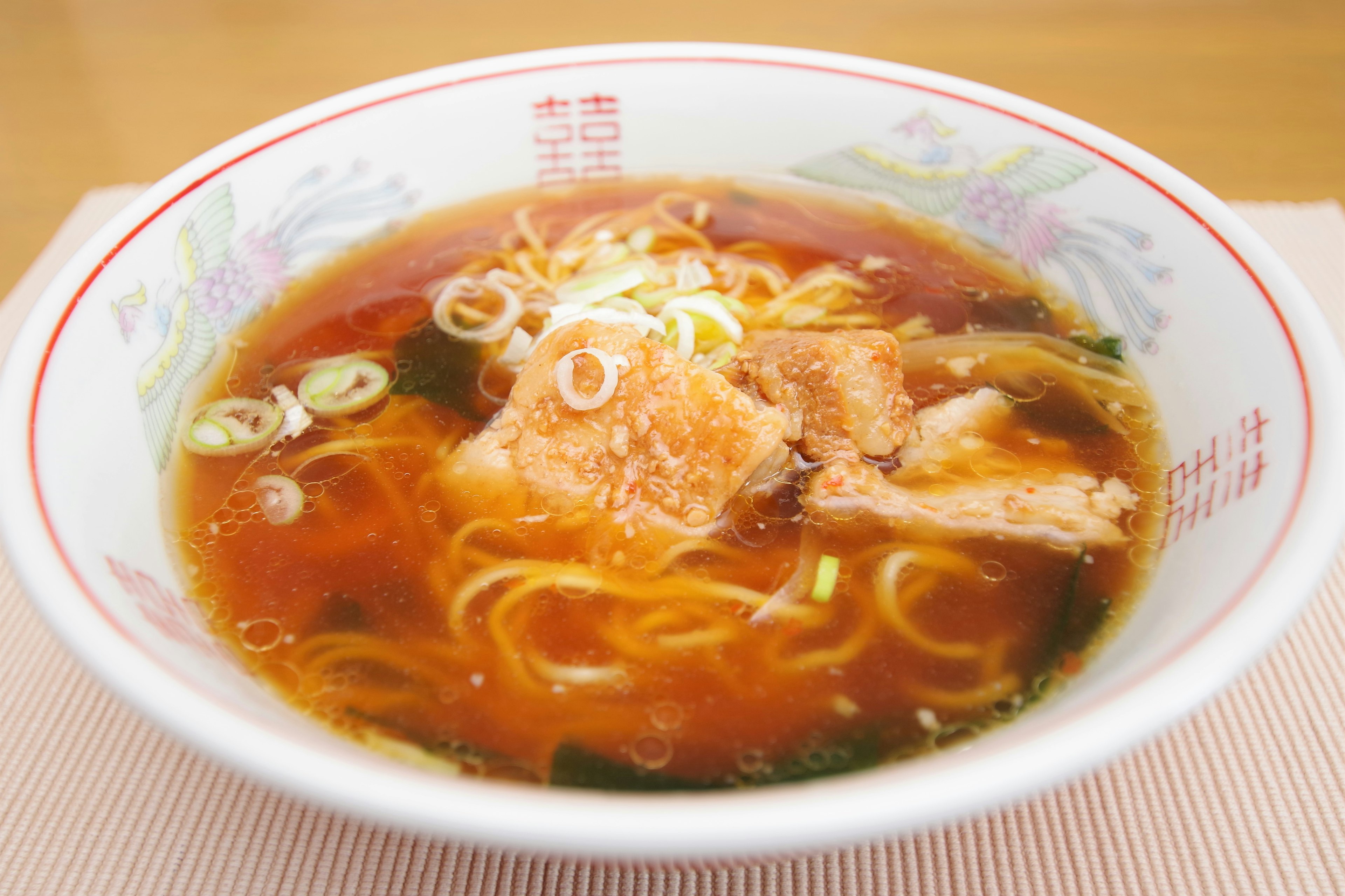 Mangkuk ramen dengan irisan chashu dan bawang hijau dalam kaldu