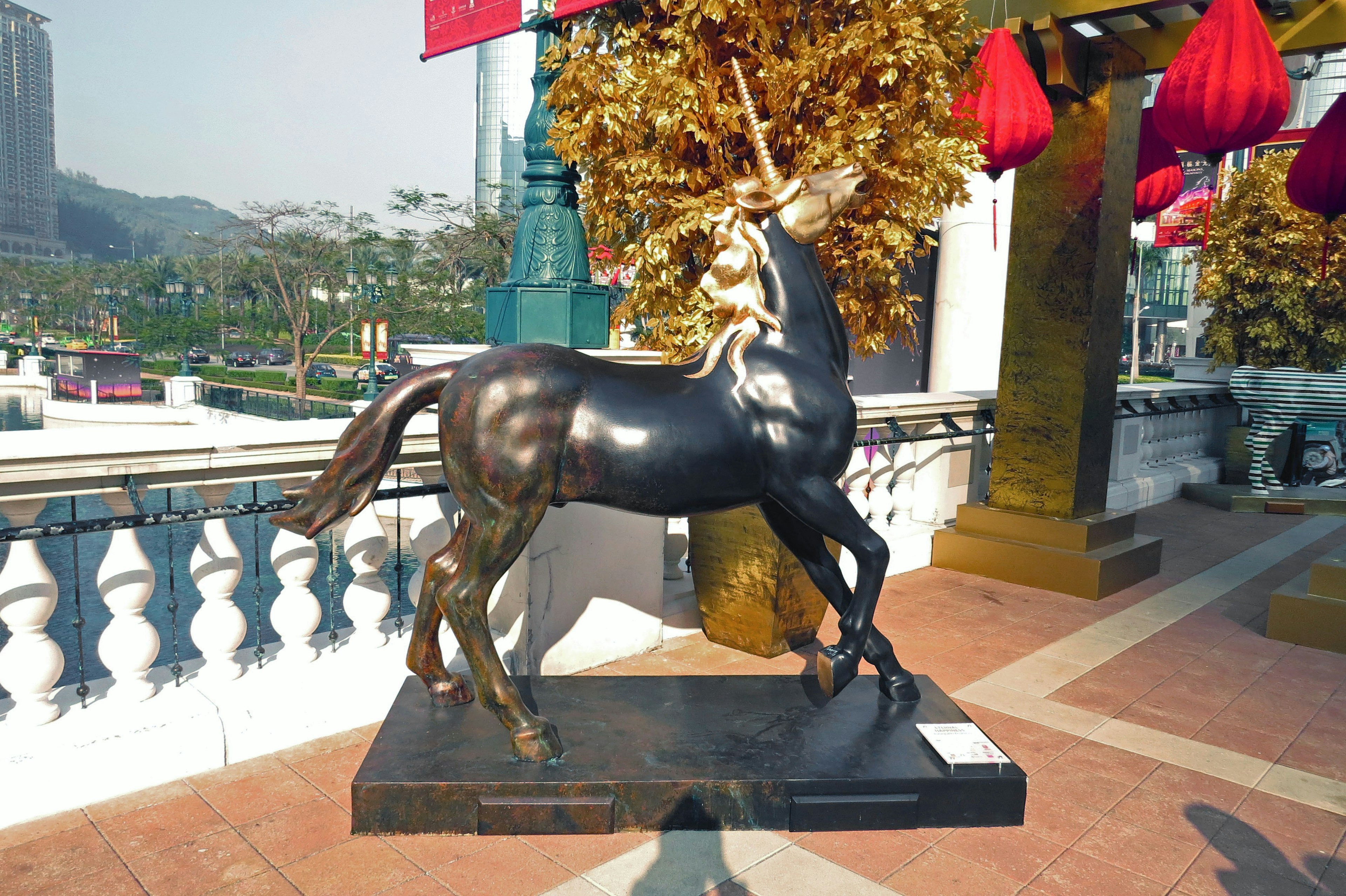 Eine Bronzestatue eines Einhorns mit einem Kind, das auf ihm reitet, in einer Außenumgebung