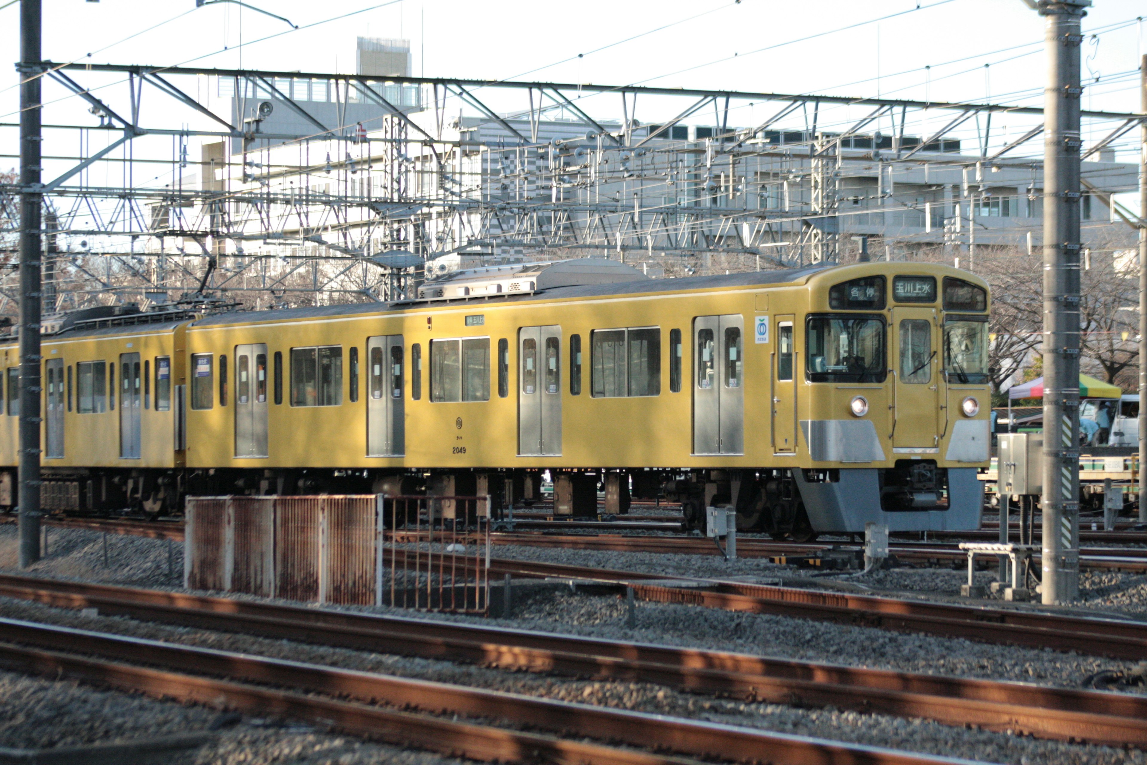 A yellow train on the railway tracks