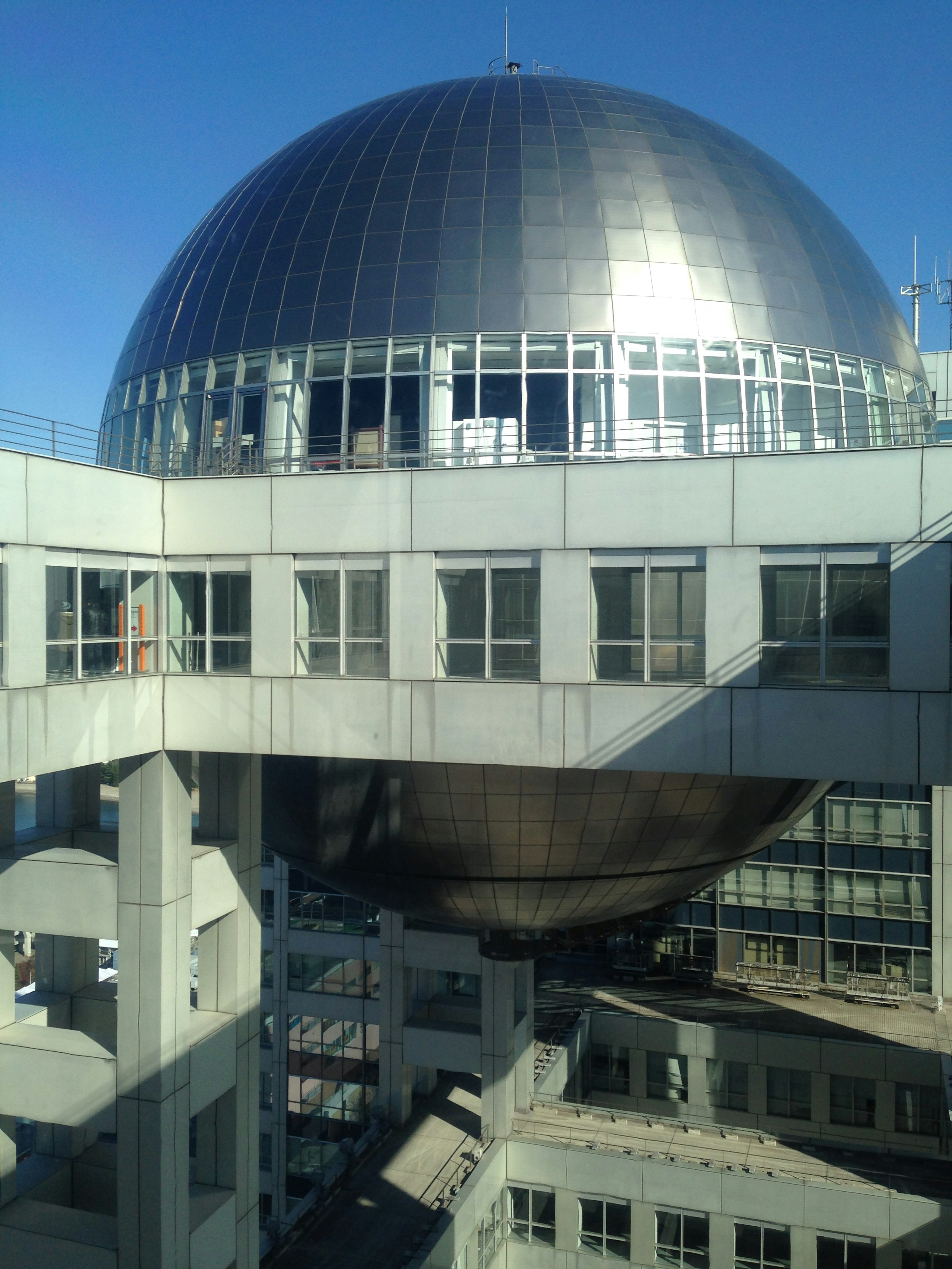 Grand dôme argenté sur le toit d'un bâtiment avec des structures environnantes