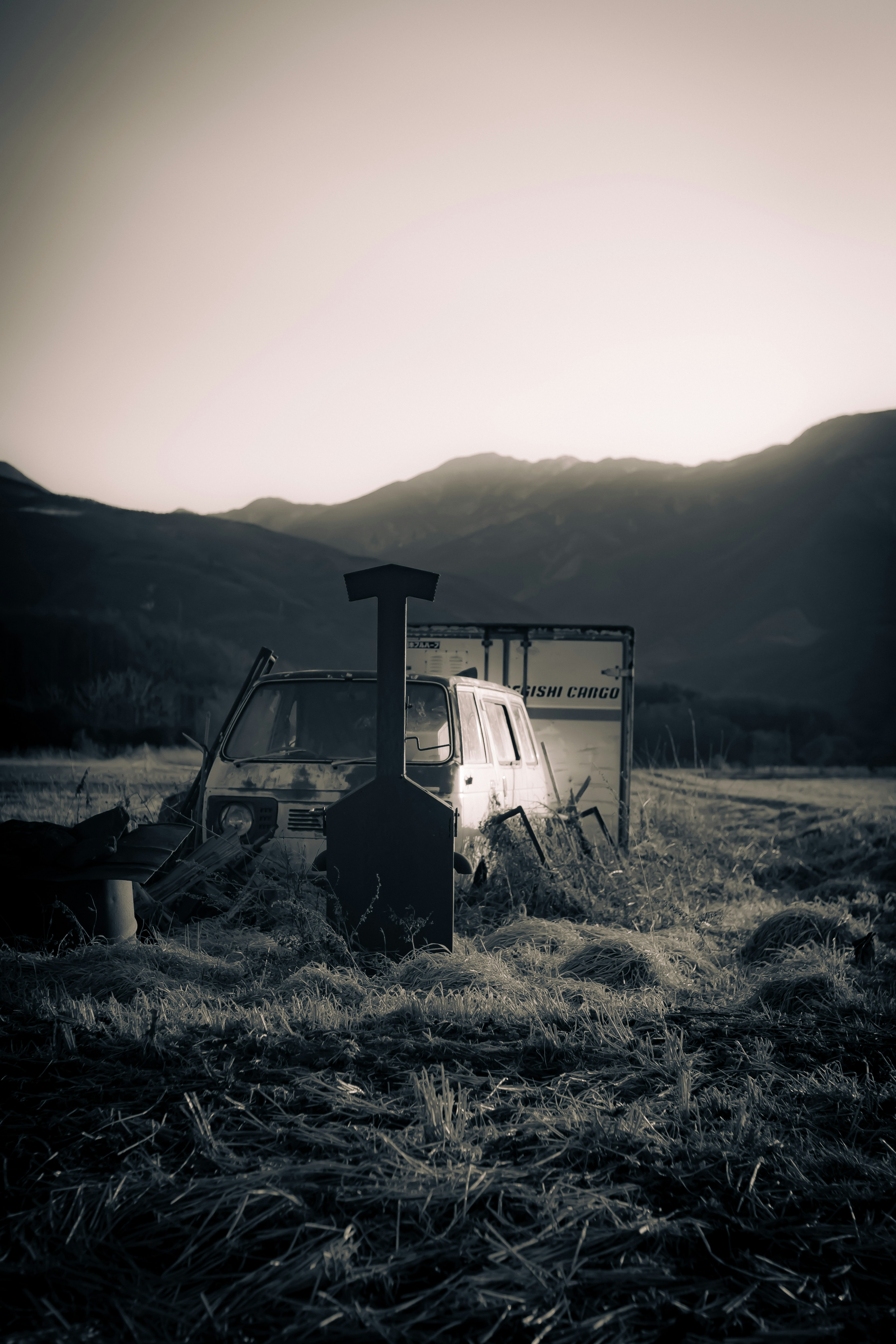 Vecchio trattore in un campo al tramonto con montagne sullo sfondo