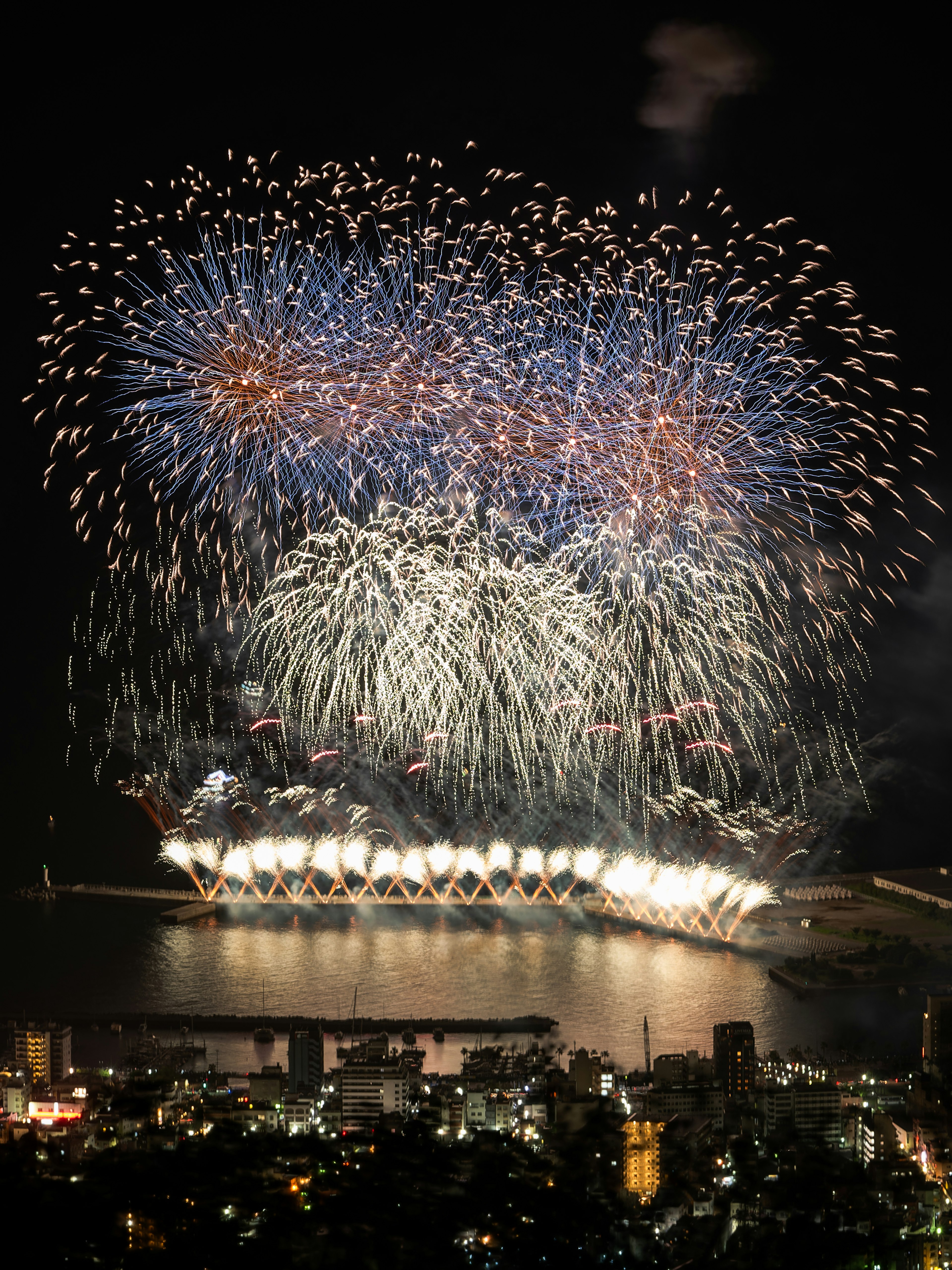 Impresionante espectáculo de fuegos artificiales iluminando el cielo nocturno con reflejos en el agua