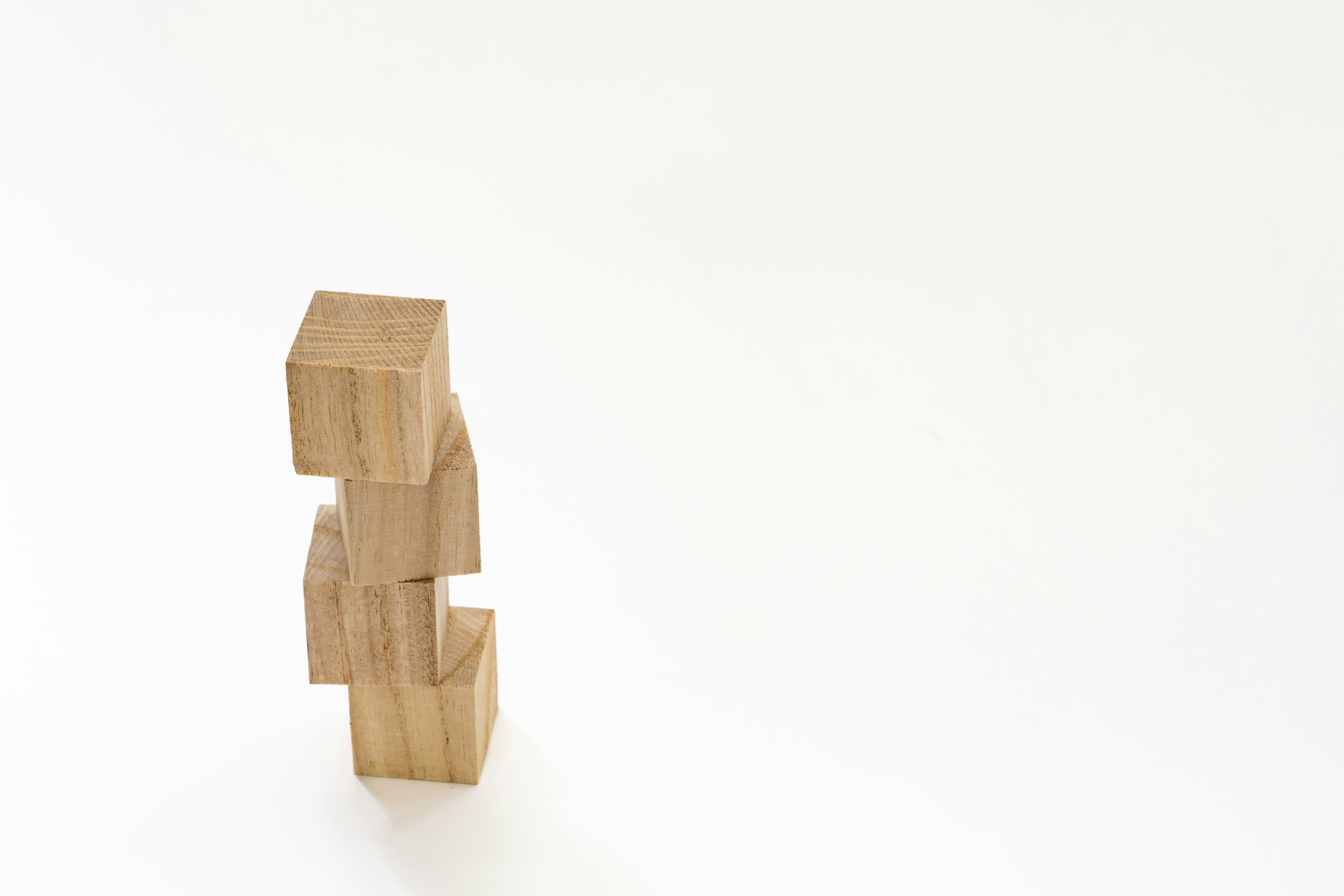 Bloques de madera apilados formando una forma única sobre un fondo blanco