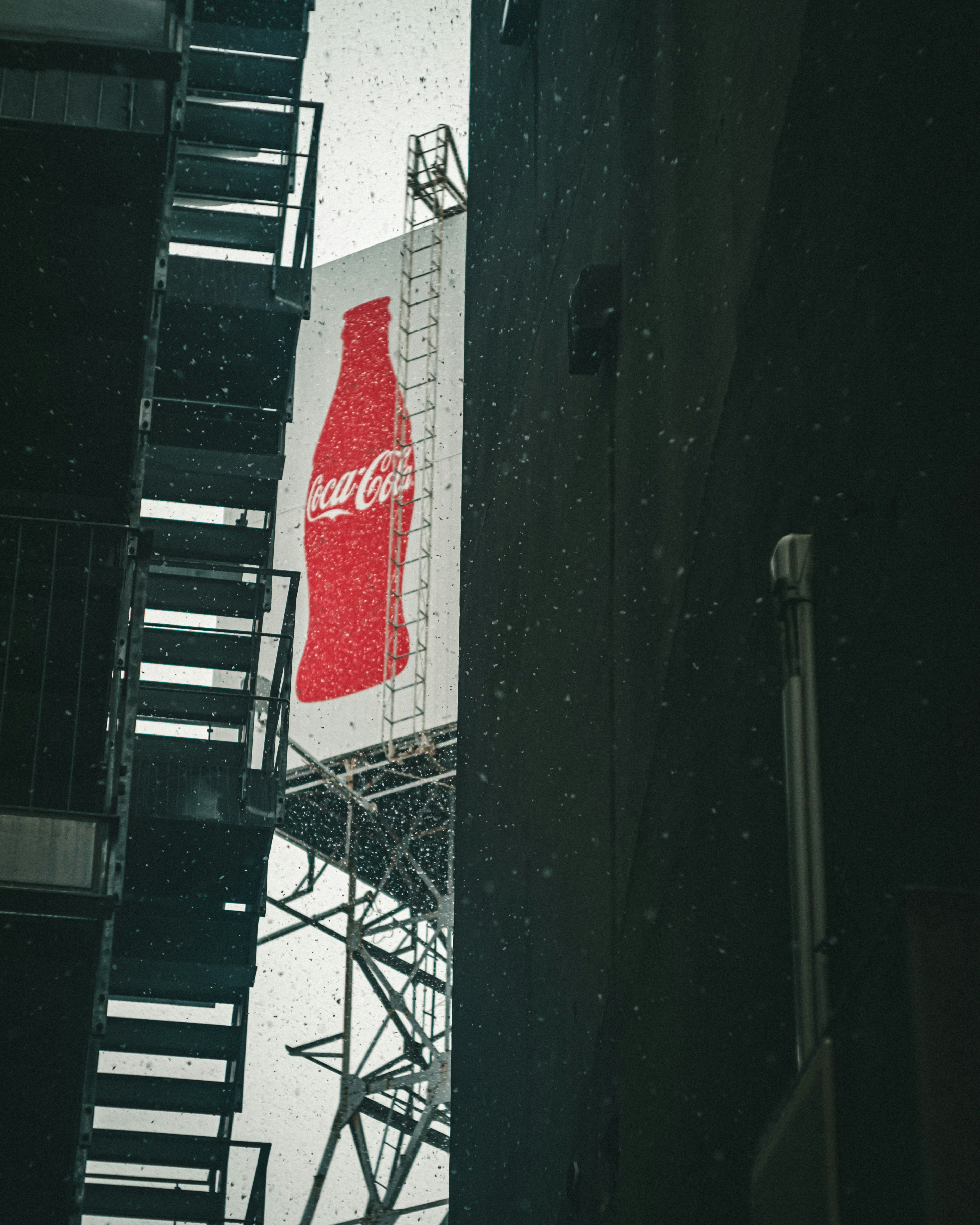 Pemandangan lorong sempit dengan papan iklan besar Coca-Cola