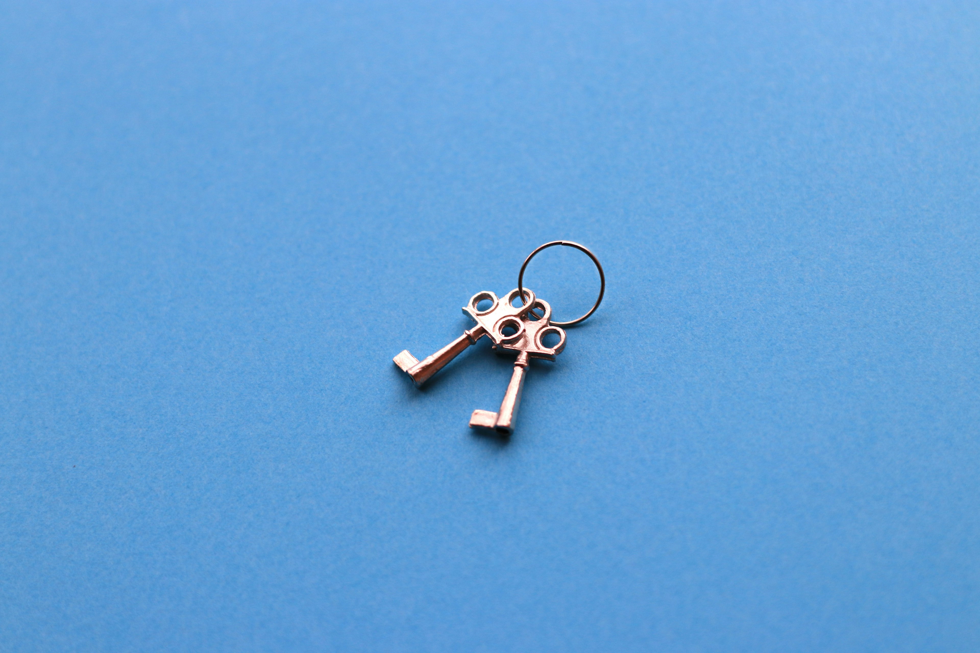 Two metal keys placed on a blue background