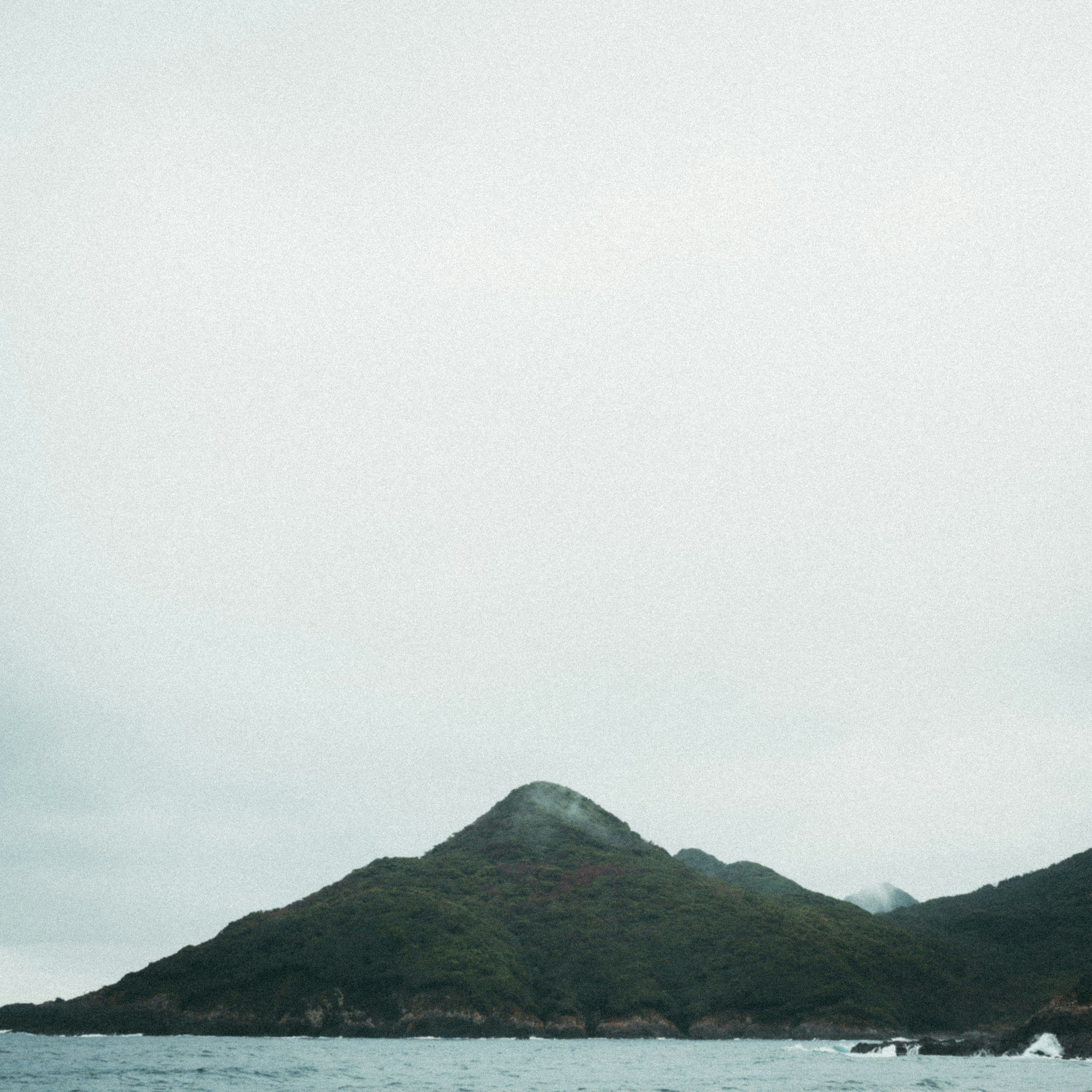 穏やかな海と霧のかかった山の風景