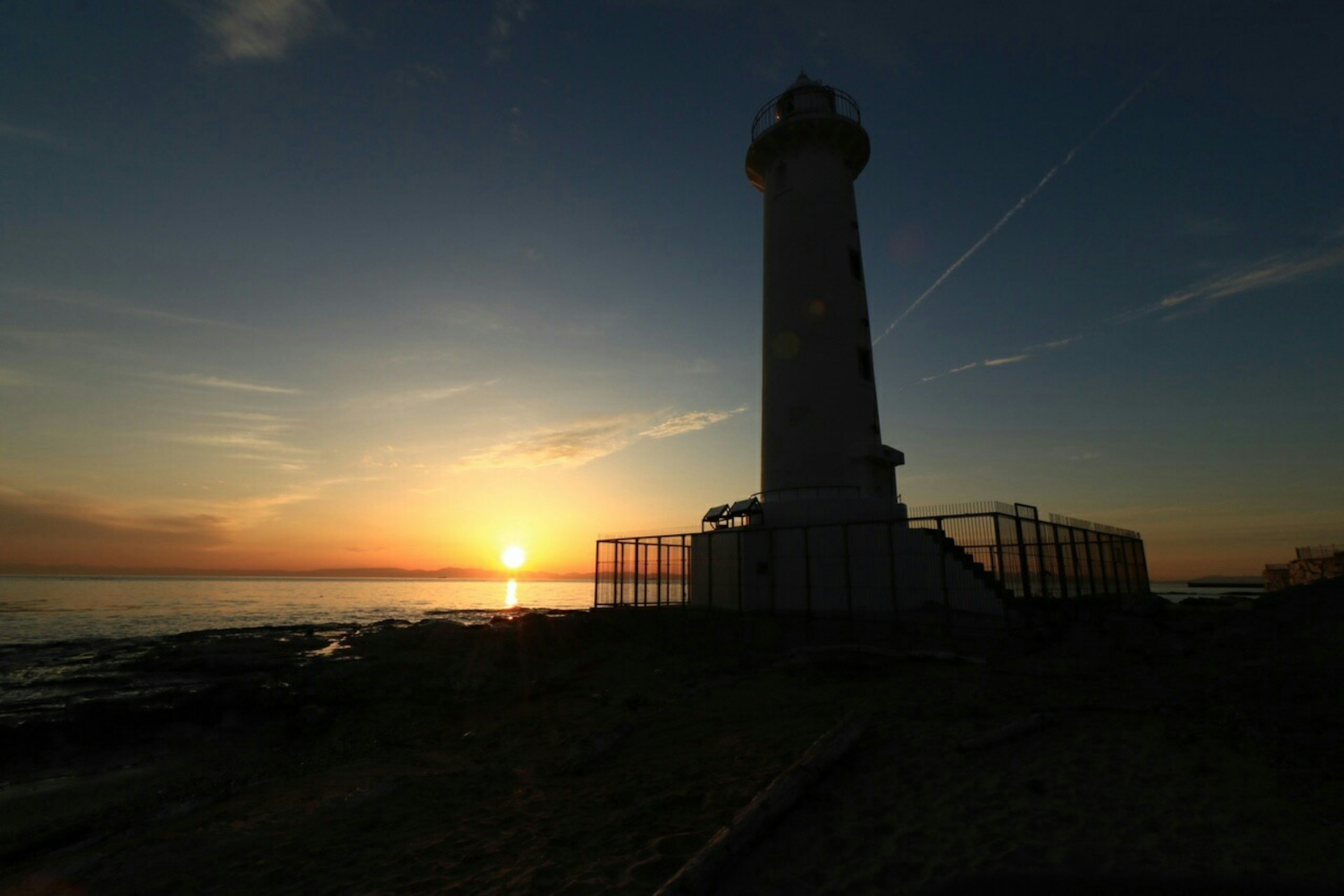 Silhouette eines Leuchtturms gegen einen Sonnenuntergang