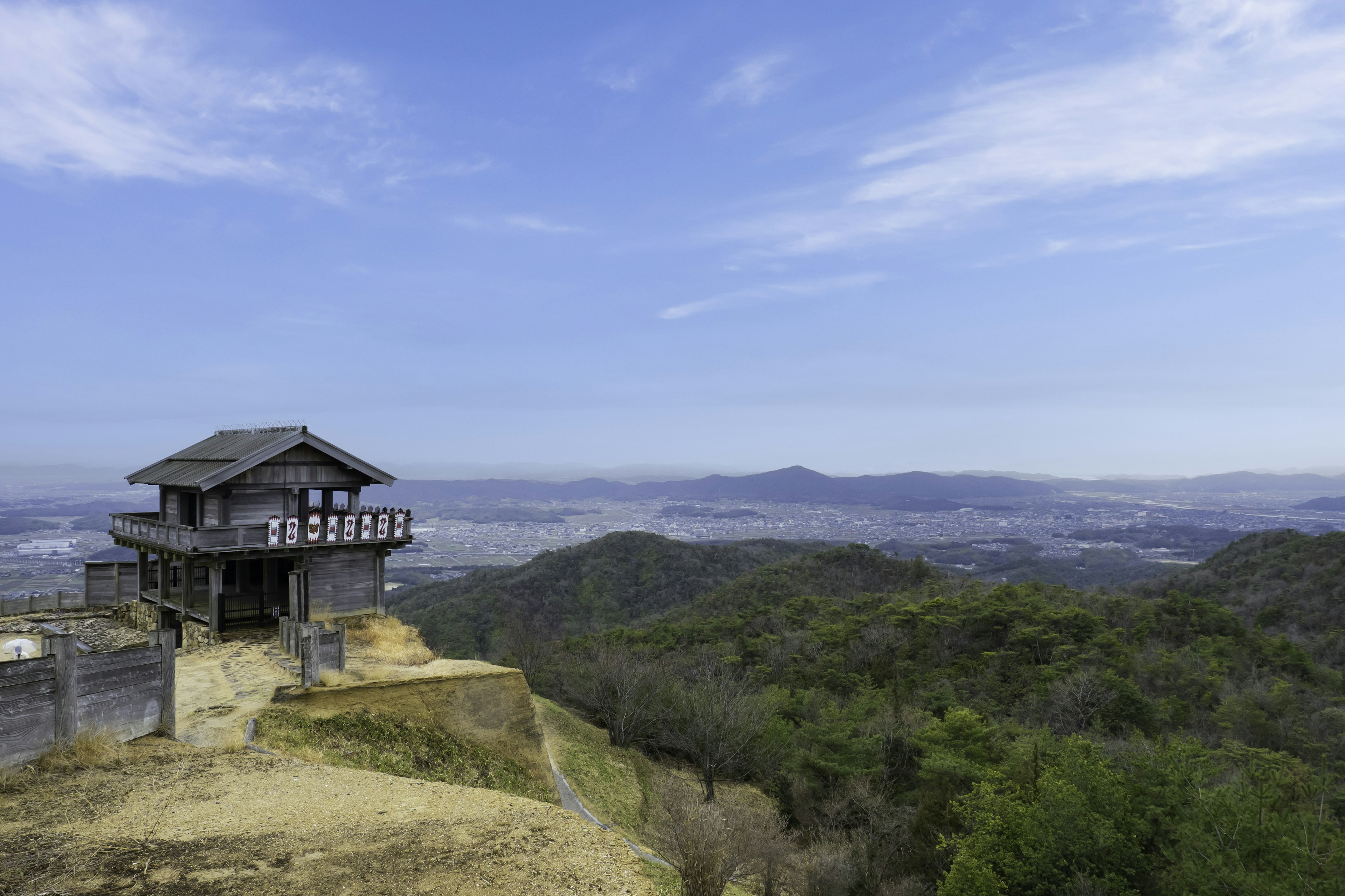 산 위의 전통 가옥과 광활한 녹색 풍경