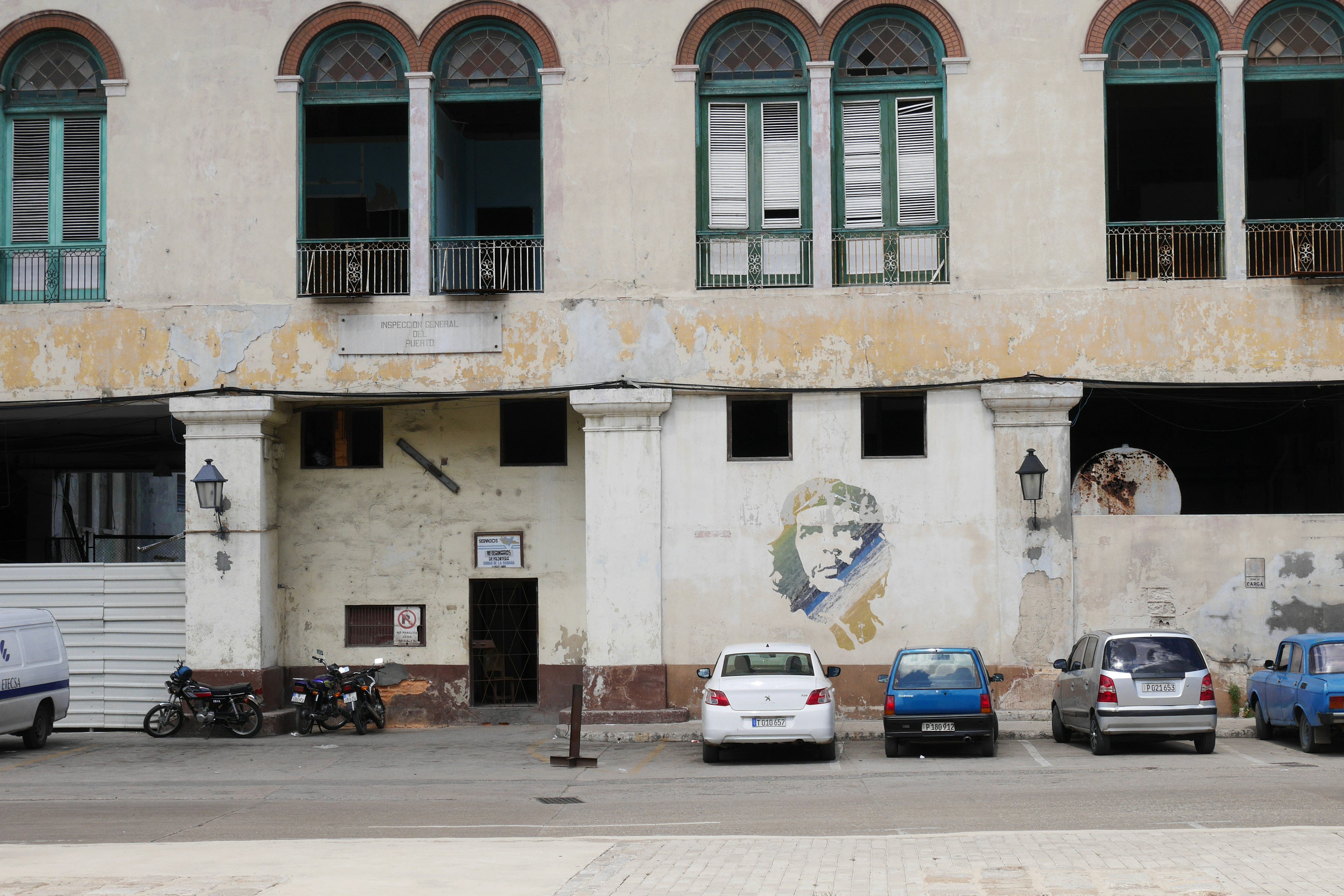 Exterior de un edificio antiguo con paredes descoloridas y ventanas en arco