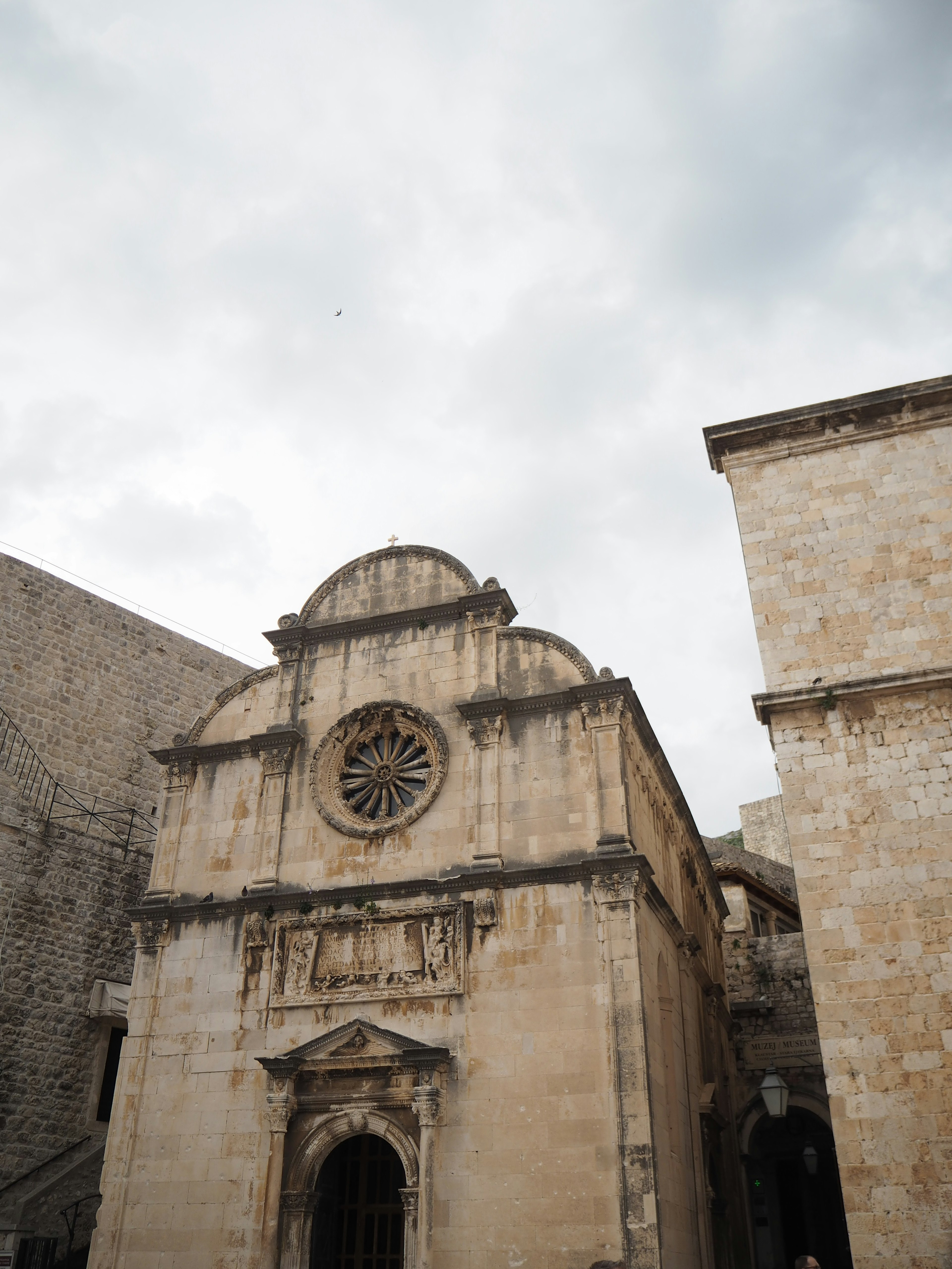 Stone church facade featuring a large rose window and historic architecture