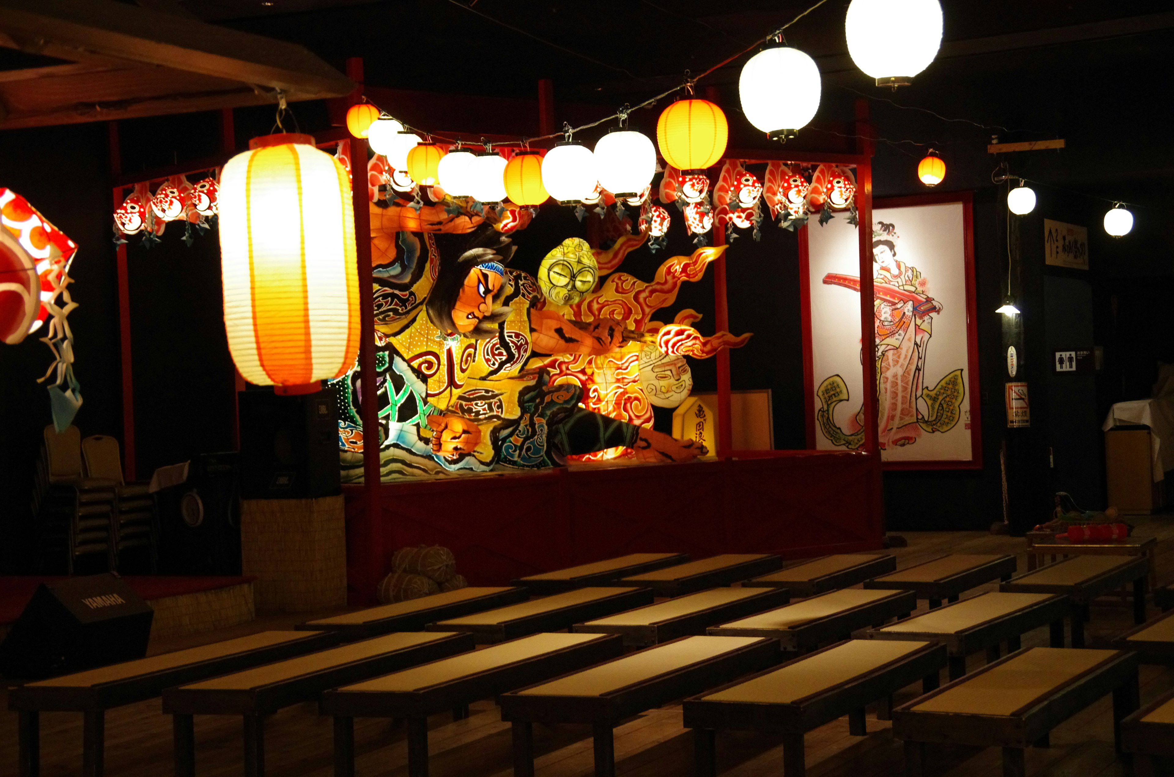 Espace intérieur décoré pour un festival japonais avec des lanternes colorées et des fresques vibrantes