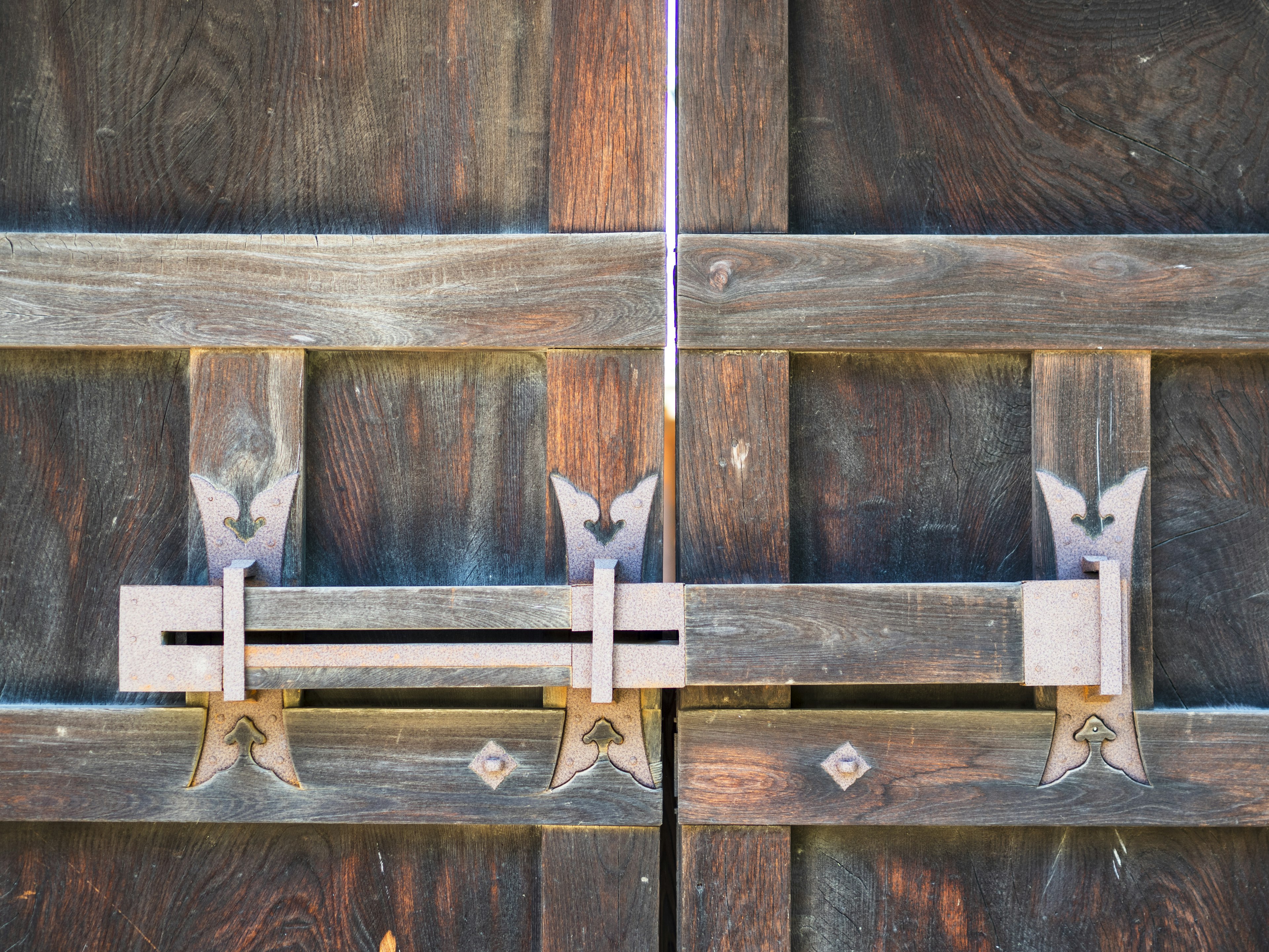 Vista dettagliata di una vecchia porta in legno con accessori metallici e chiavistello