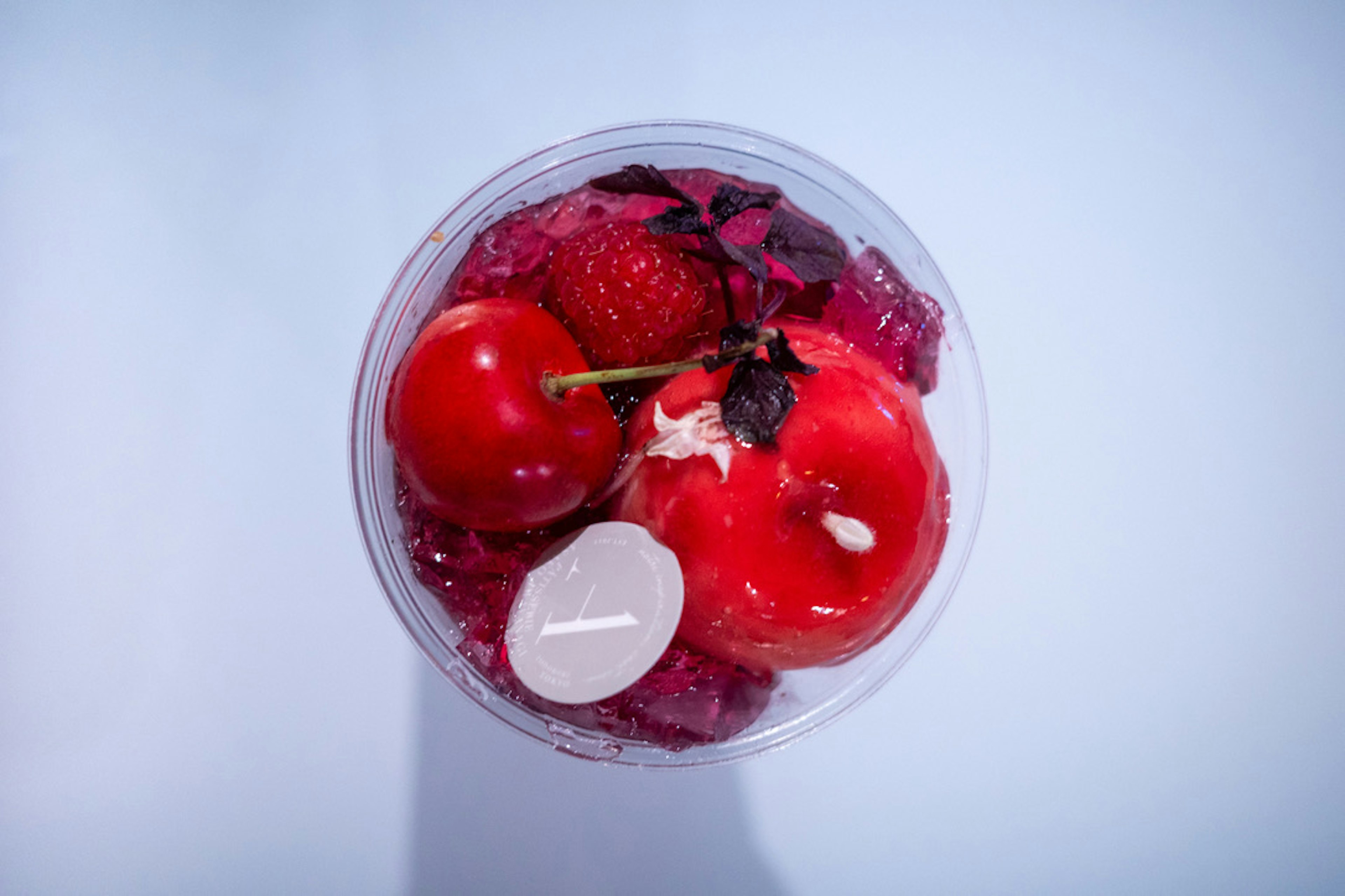 Top view of a cup filled with red fruits and jelly dessert