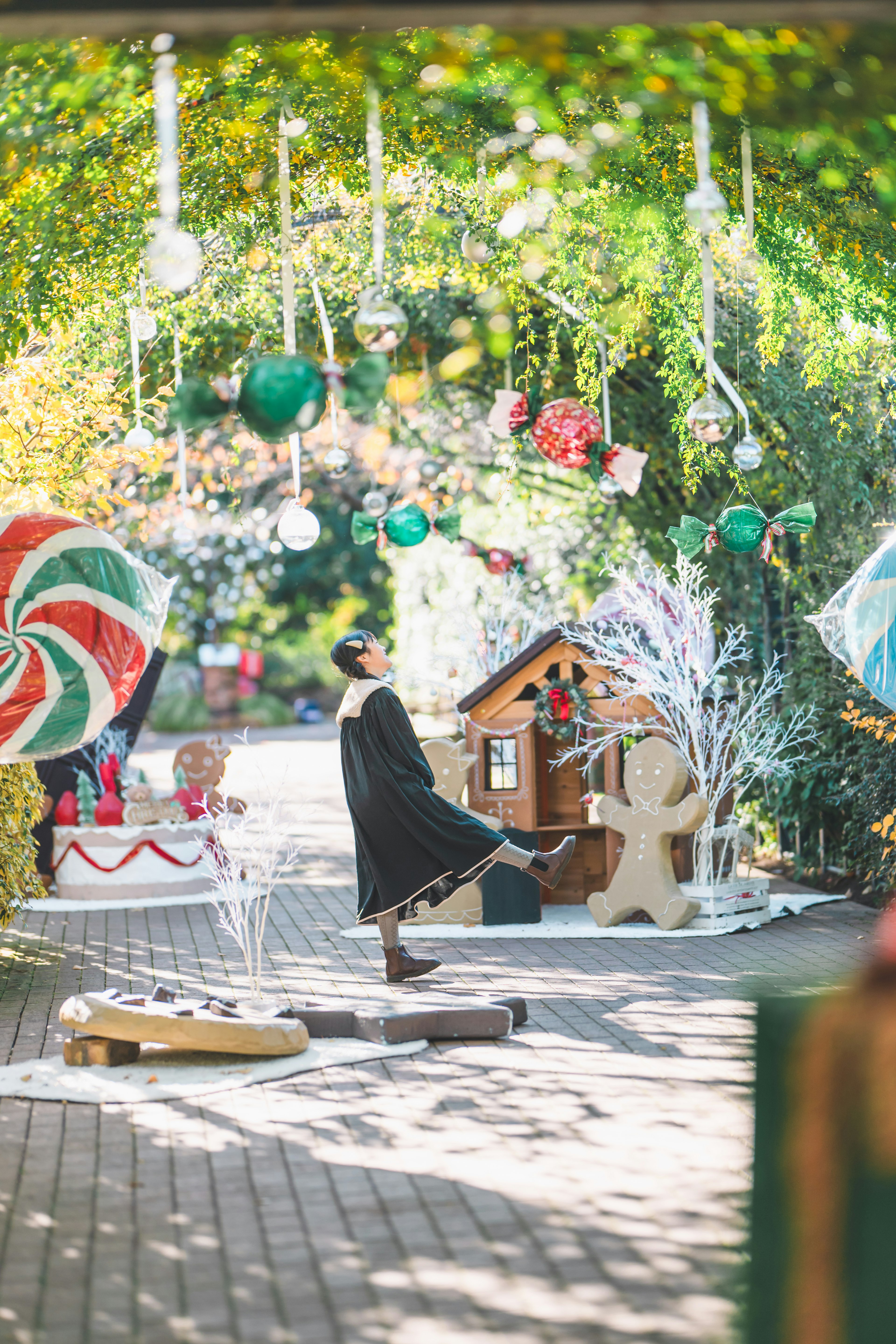 Area di decorazione natalizia all'aperto con ornamenti colorati e una casetta di pan di zenzero