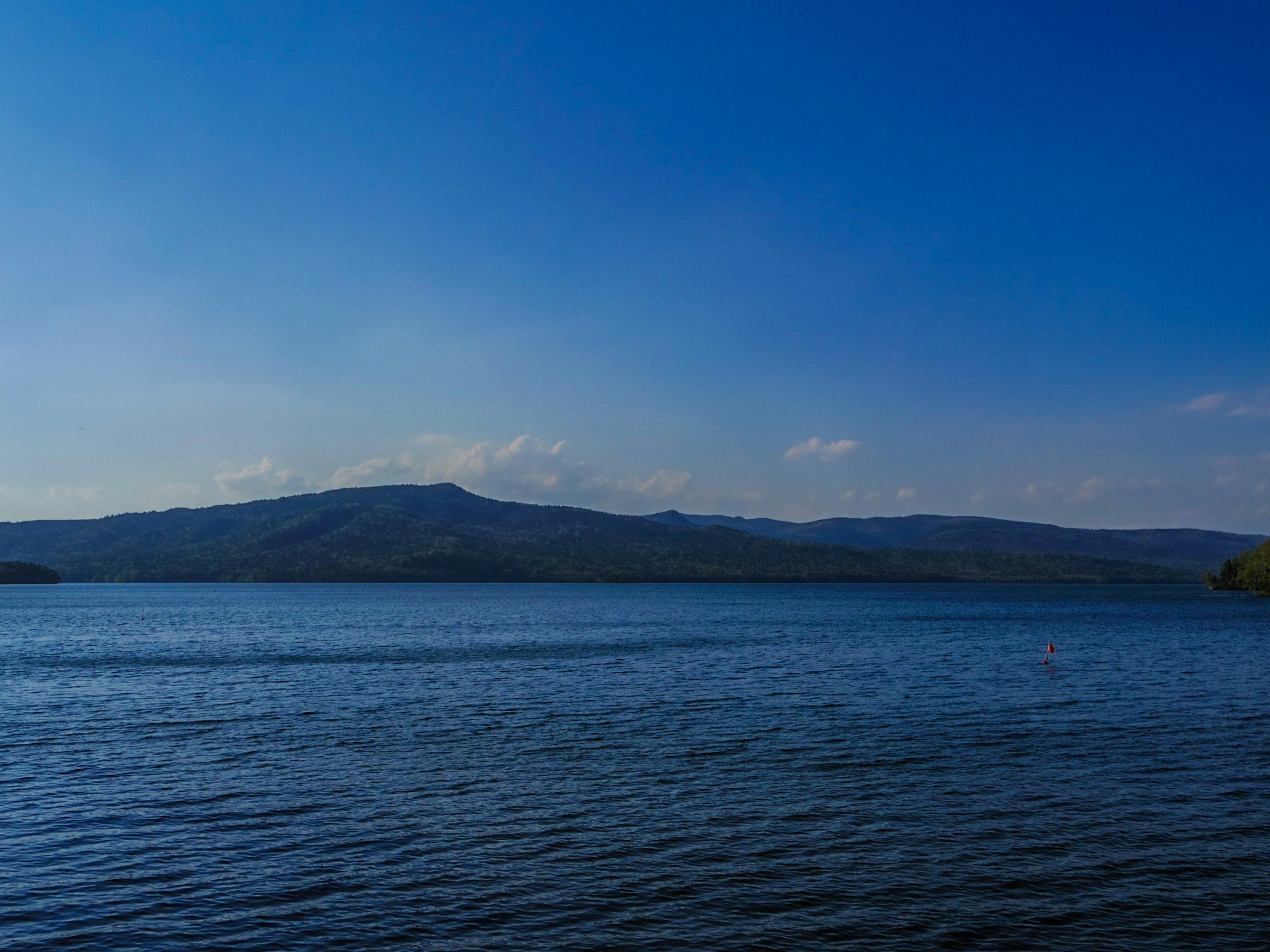 Scenic view of a blue lake with gentle hills in the background