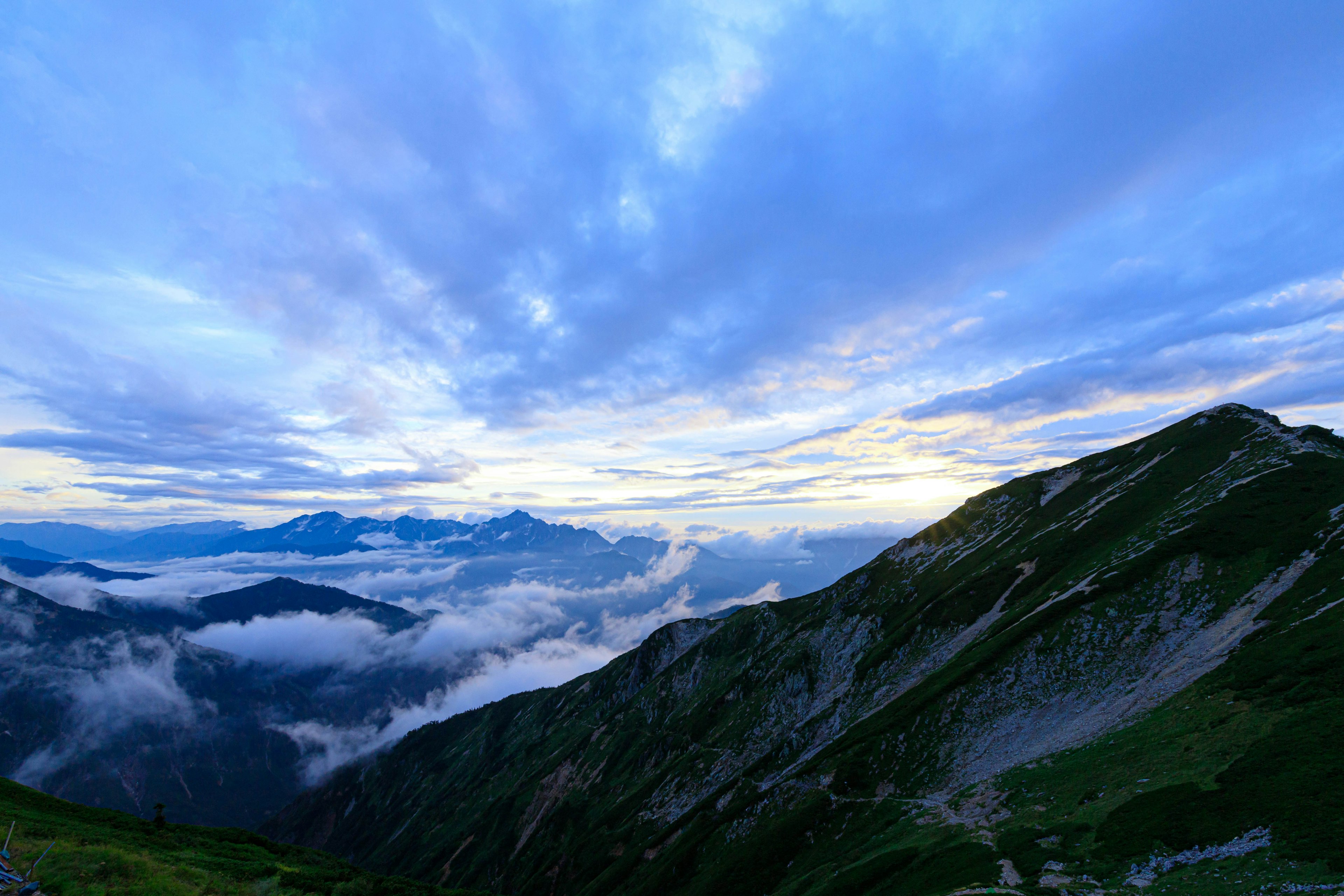 Scenic view of mountains under a blue sky with clouds