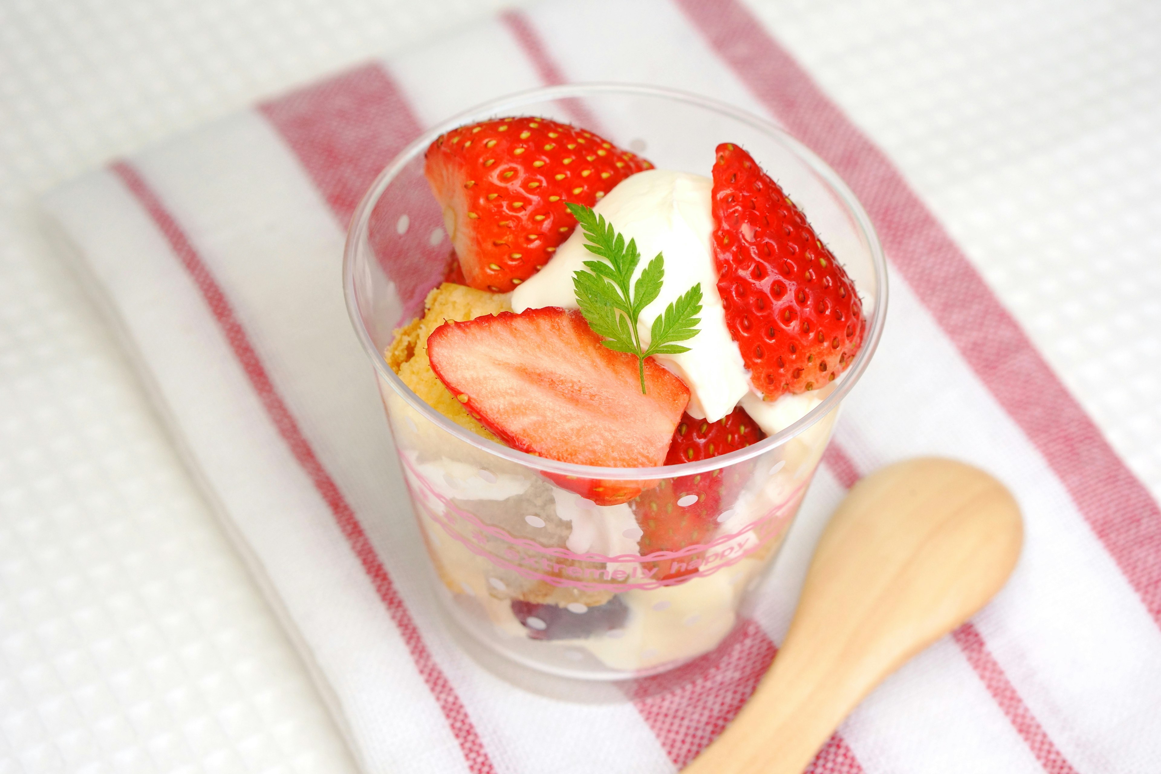 Coppa di dessert con fragole e panna posata su un asciugamano bianco