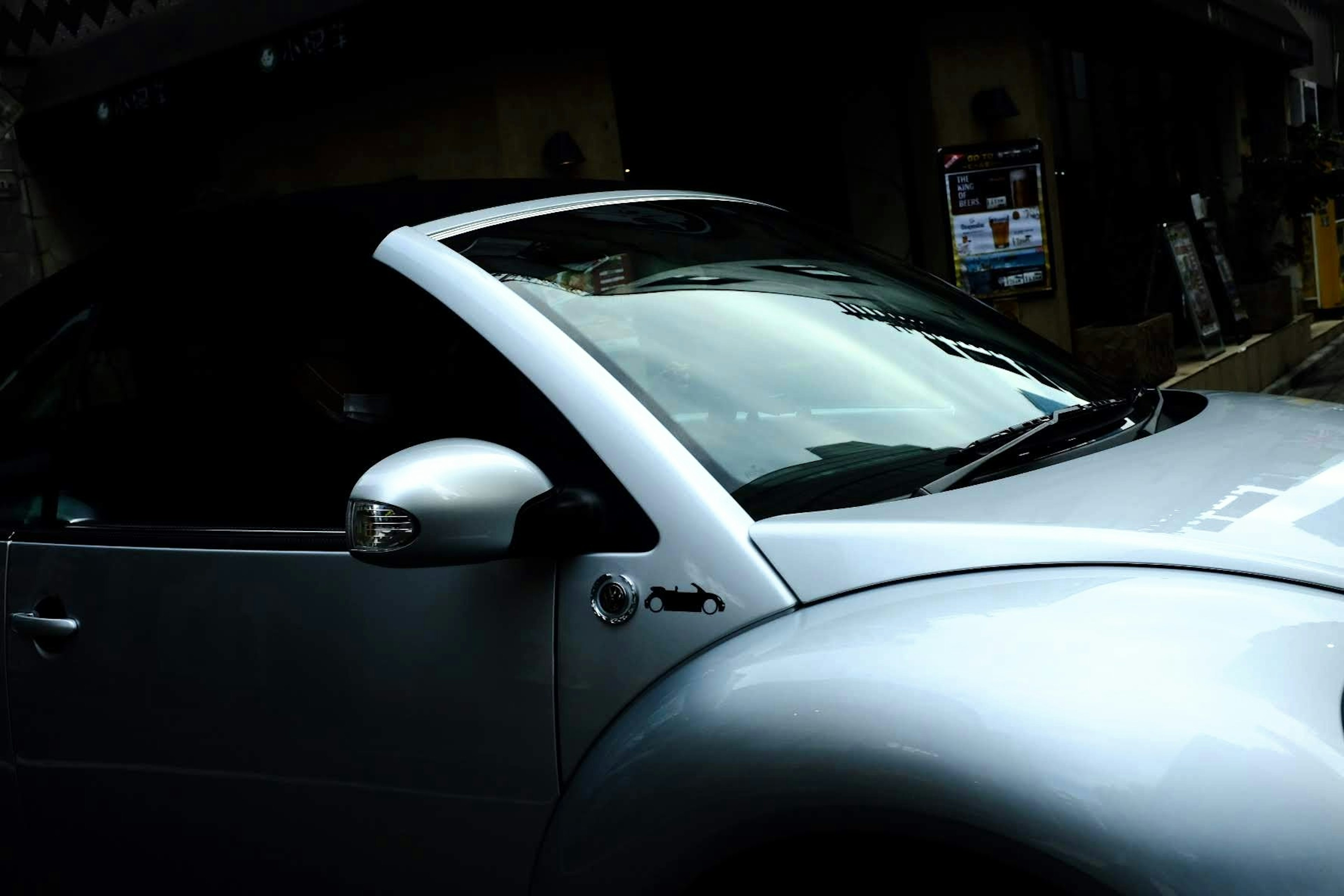 Vista lateral de un coche plateado con un diseño único