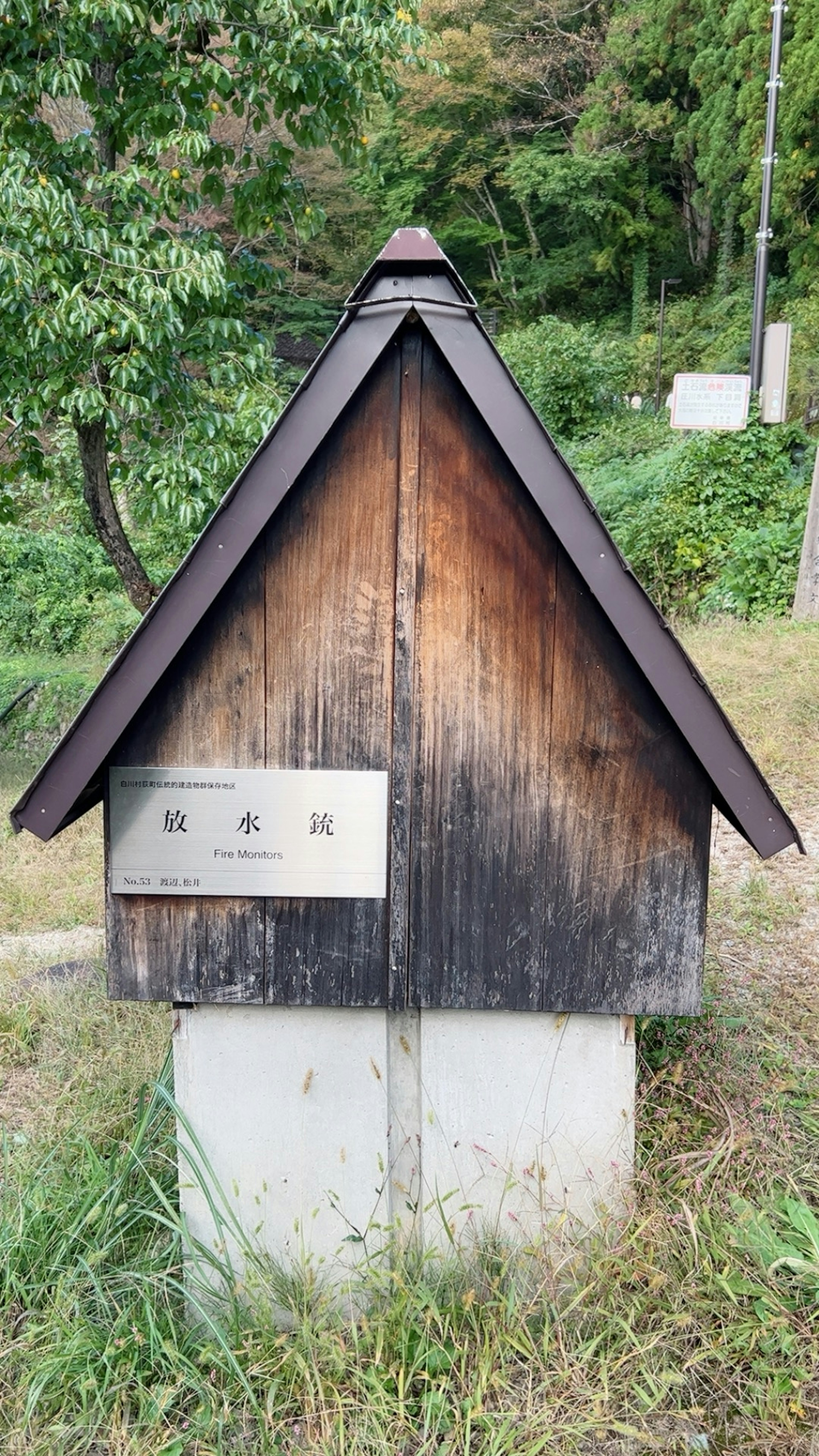 木製の小屋とコンクリートの基盤がある風景