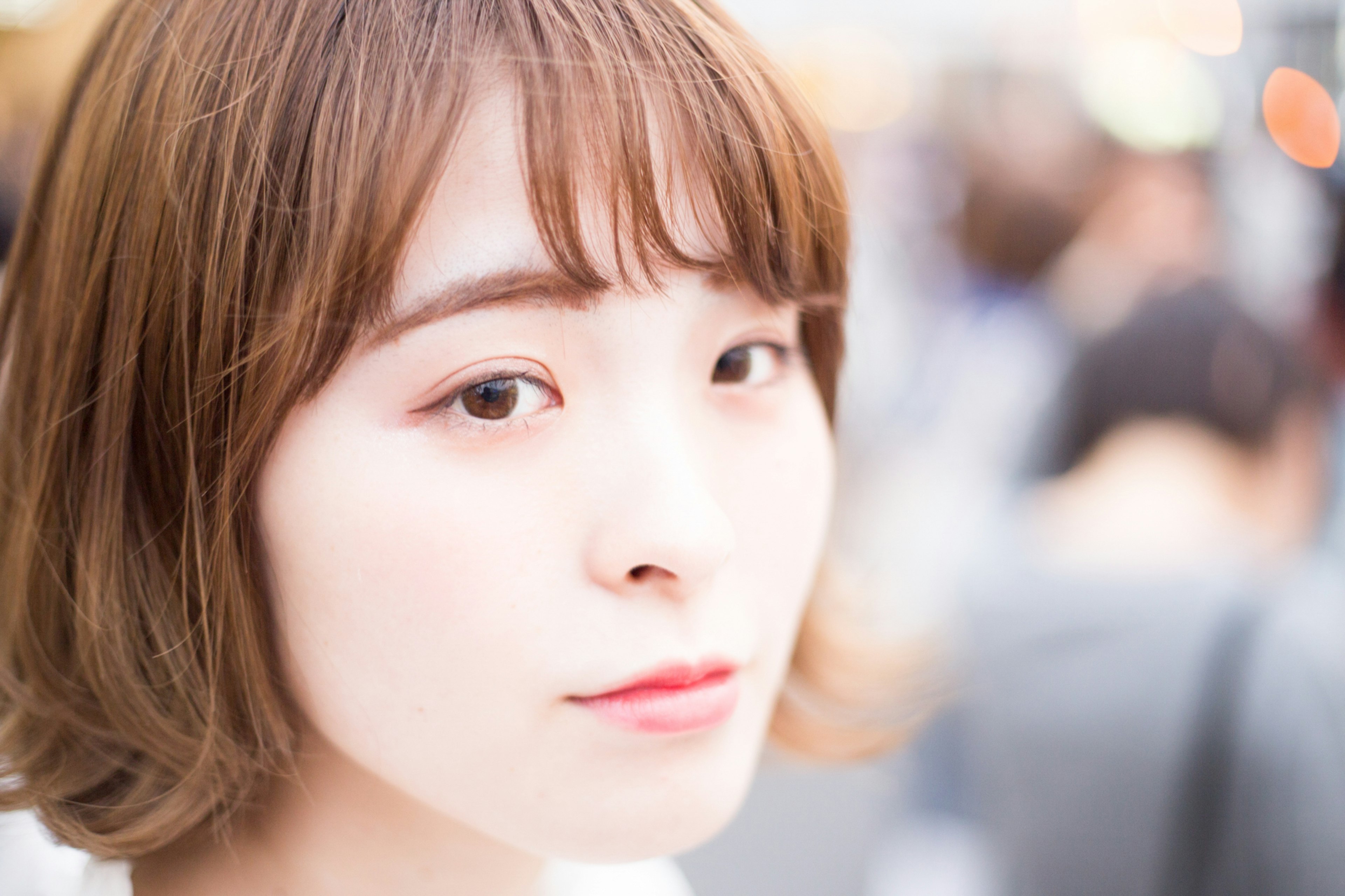 Close-up image of a woman's face with short brown hair and striking eyes