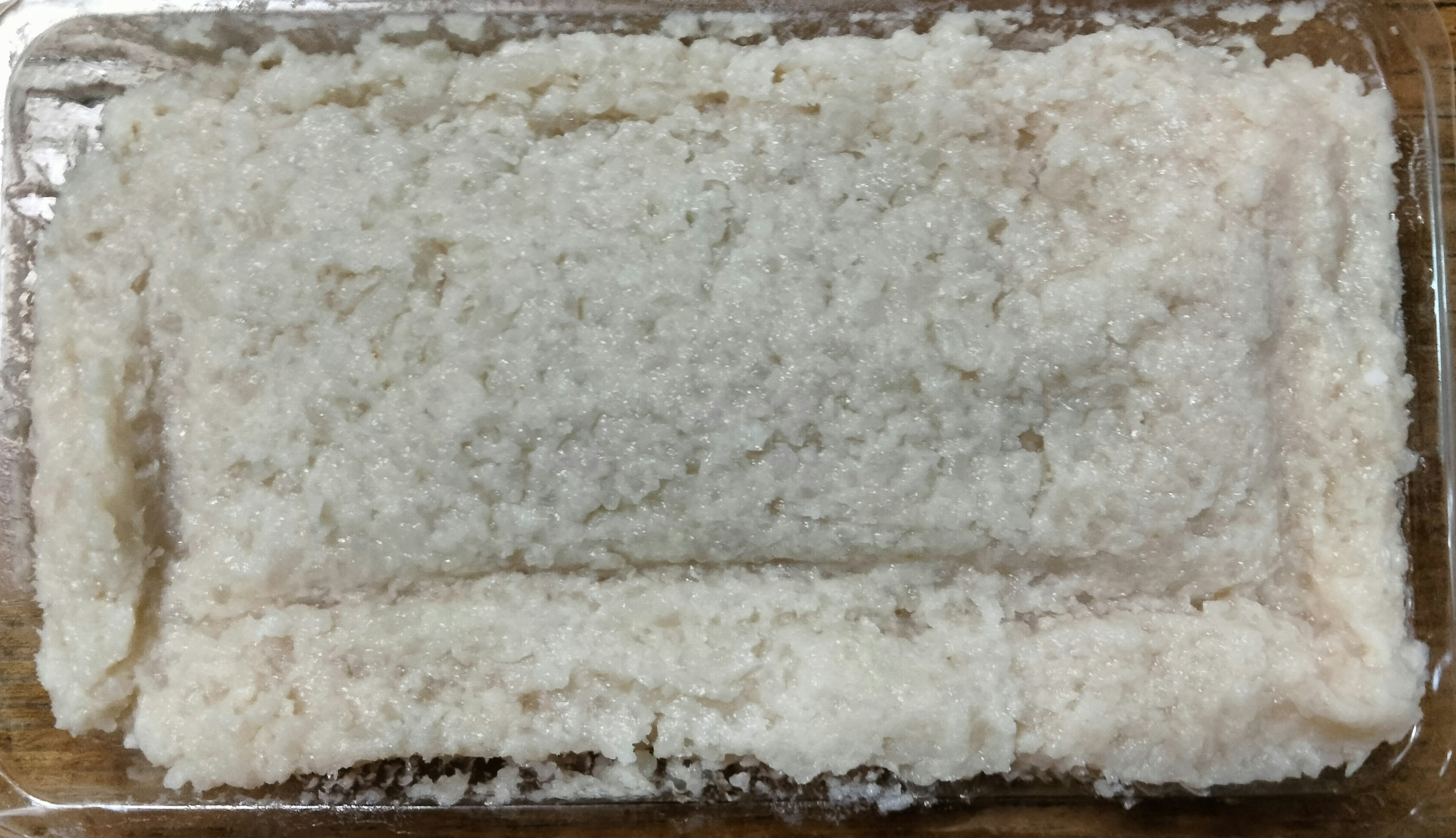 A rectangular block of white rice flour on a glass dish