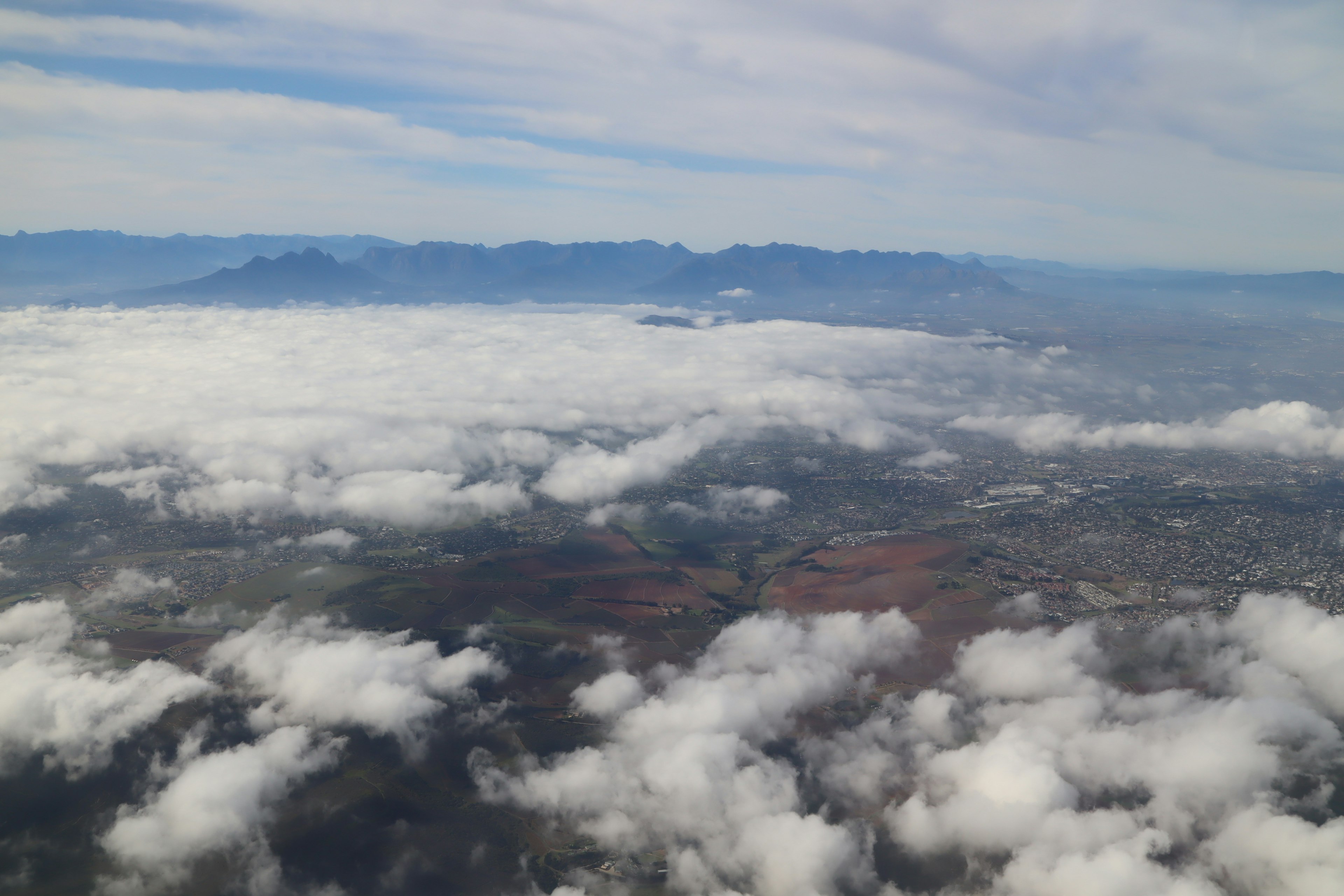 Vista aerea di montagne e pianure sopra le nuvole