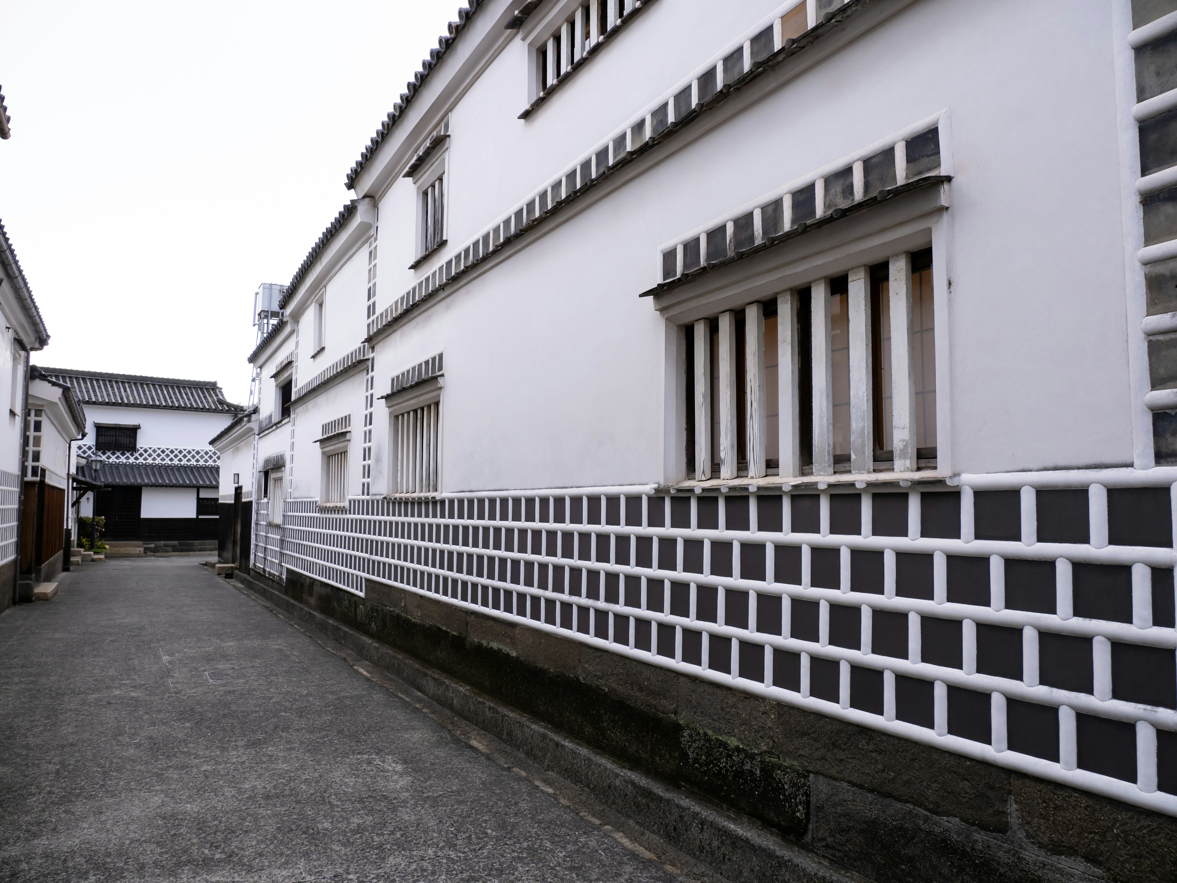 Una escena de calle tranquila con edificios blancos y un camino de adoquines