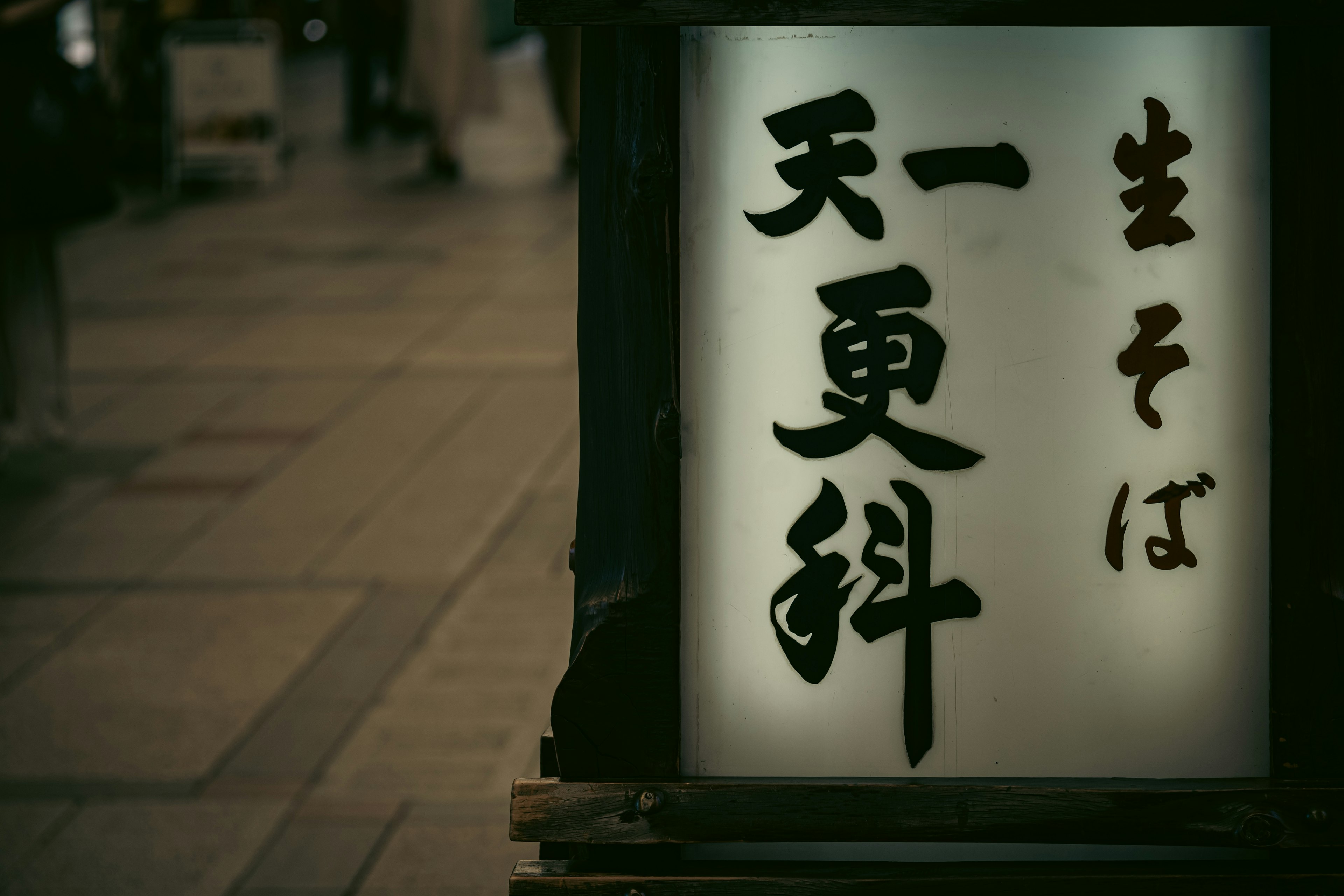 A street scene featuring a sign for fresh soba at Tenkoshina